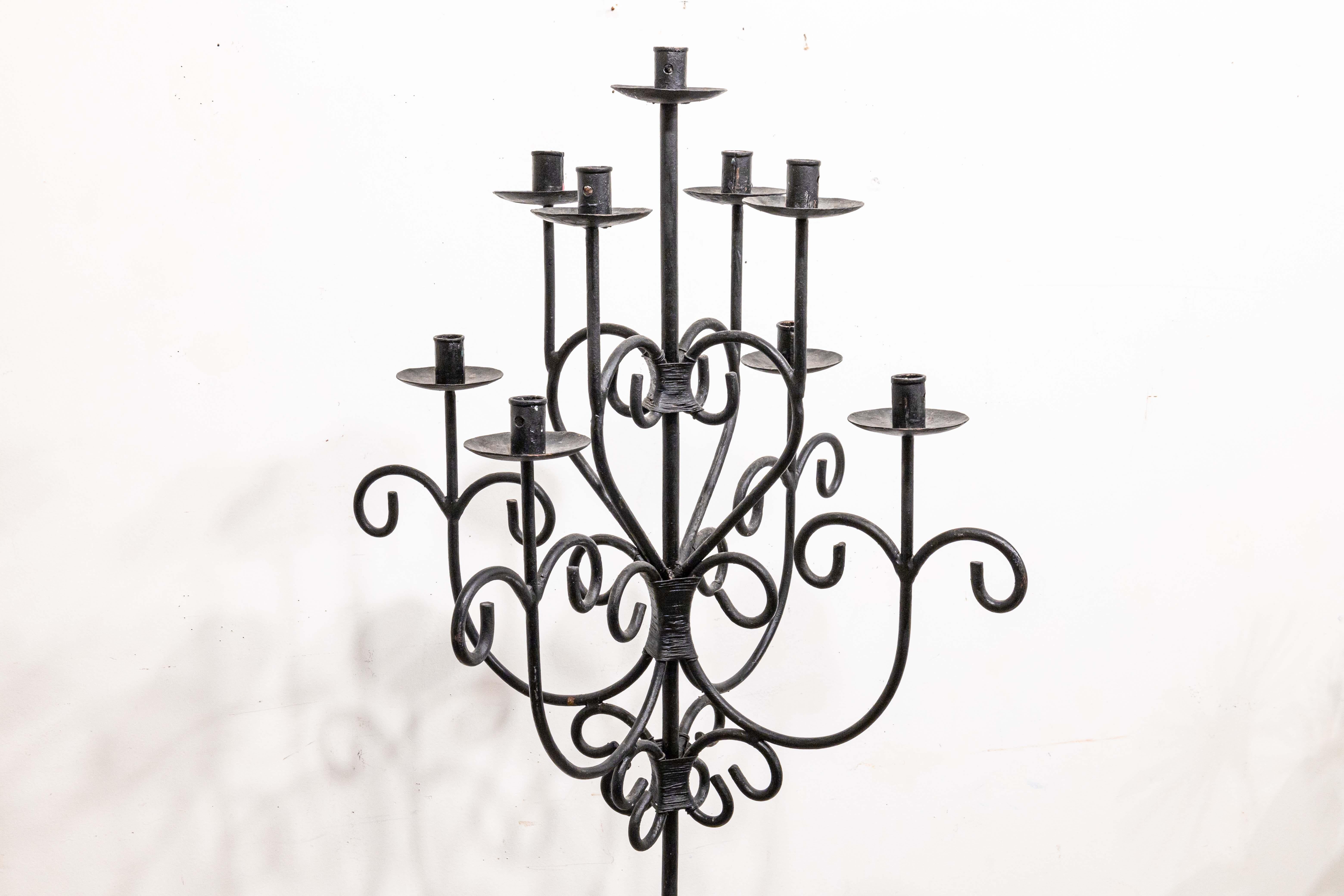 Un candelabro gotico d'epoca a piantana. Uno splendido pezzo caratterizzato da una struttura in ferro battuto nero opaco. Questo pezzo presenta un design completamente simmetrico, con motivi a cuore in tutta la vorticosa lavorazione del metallo.