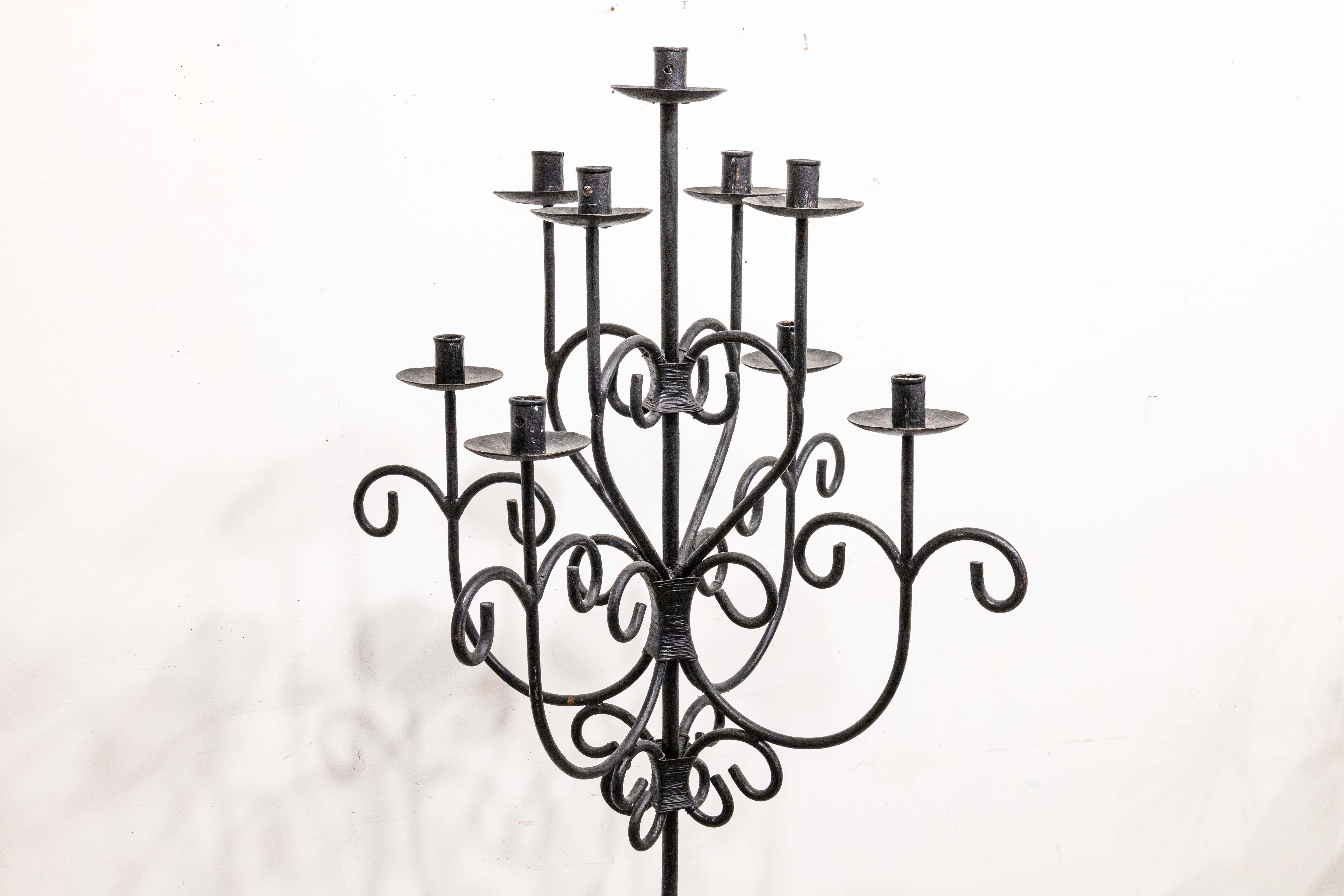 A vintage gothic free standing candelabra. A gorgeous piece featuring a matte black wrought iron construction. This piece features a fully symmetrical design, with heart motifs throughout the swirling metalwork. This piece has 9 available candle