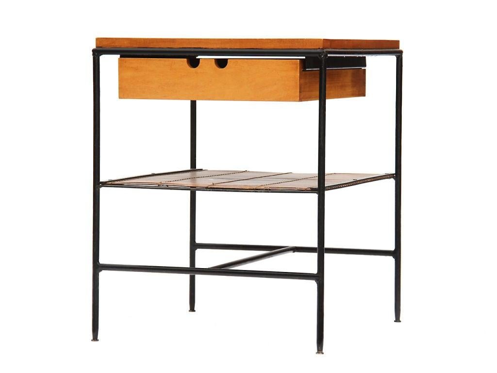 Highly desirable Paul McCobb #1572 nightstand or occasional table from his Planner Group collection for Winchedon, c. 1950s. It features an exposed black wrought iron frame, single maple drawer and top, and lower shelf made from bamboo
