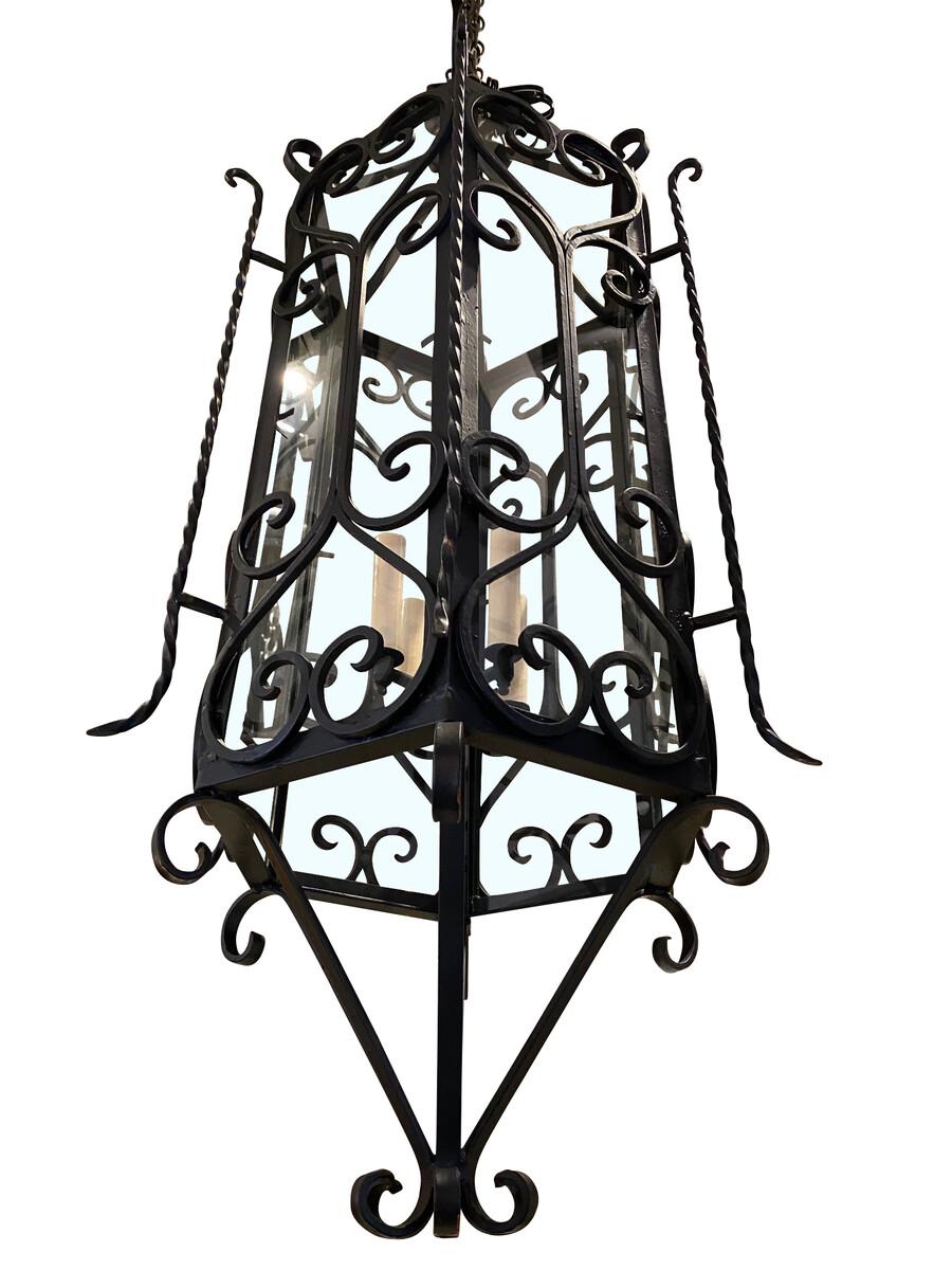 1950s pair black wrought iron lanterns in a hexagonal shape.
The glass panels are with ornate decorative iron overlays.
The lanterns have been newly rewired.
Four candelabra bulbs.