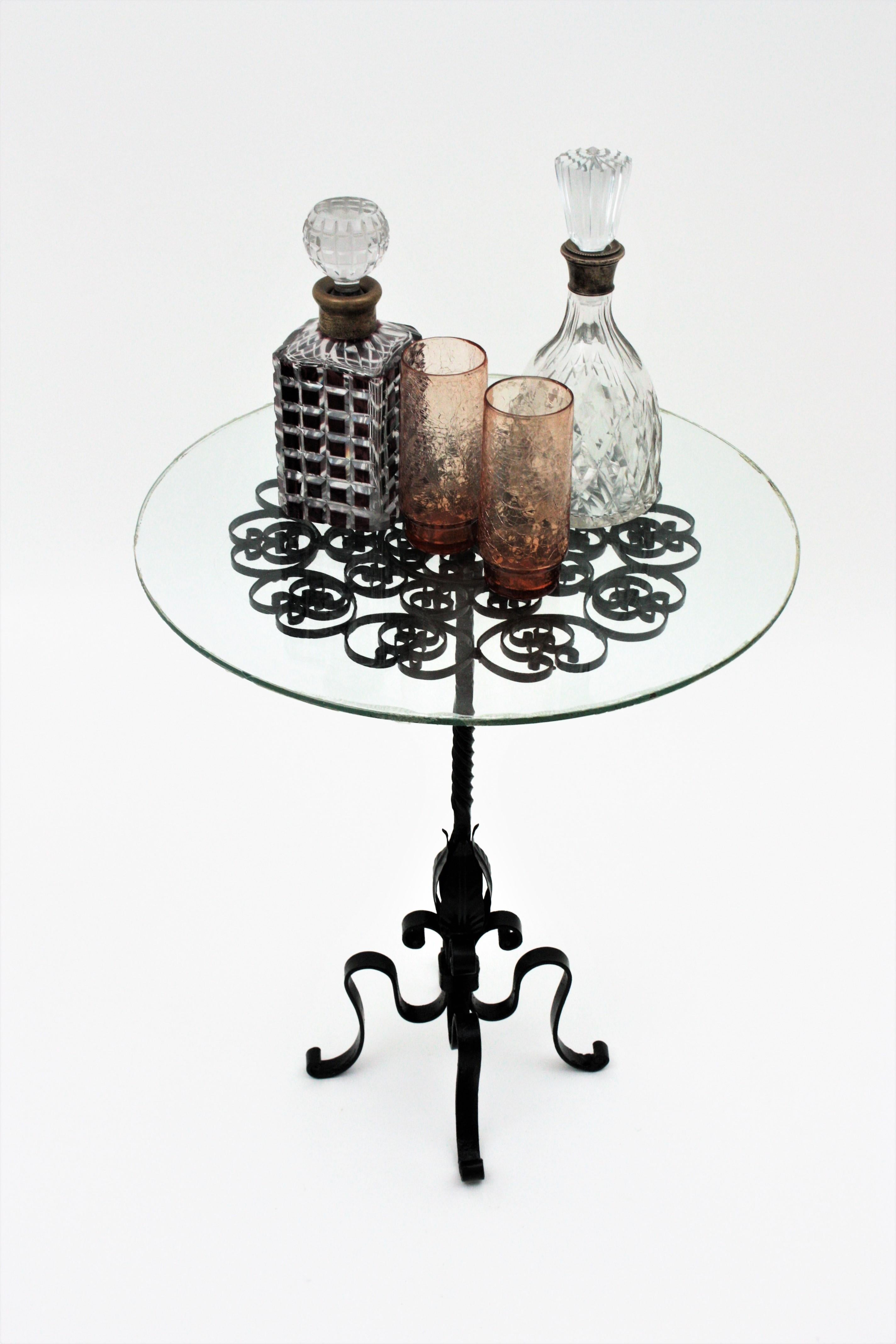 Black painted wrought iron round gueridon table with scroll detailed top, Spain, 1950s
The top is comprised by an intricate of scrolled iron pieces creating a beautiful effect. It stand on a four footed base with leafed accents and twisting