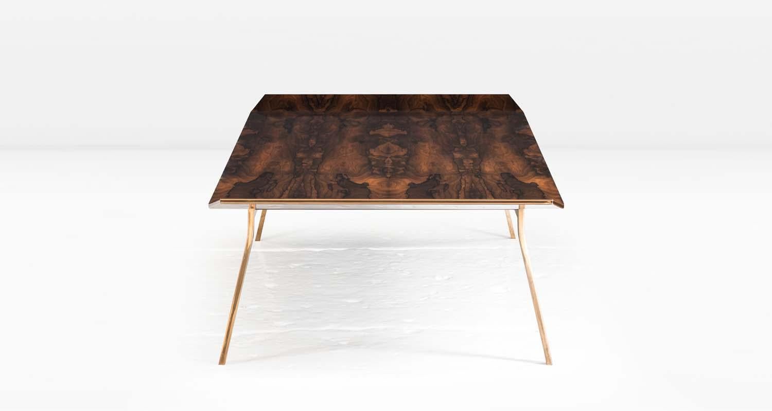 The Blackburn Coffee Table's top is comprised of alternating layers of wood and metal which are expressed along the table’s edges and is subtly articulated at both ends. The metal base is shown in polished Silicon Bronze with a patinated interior
