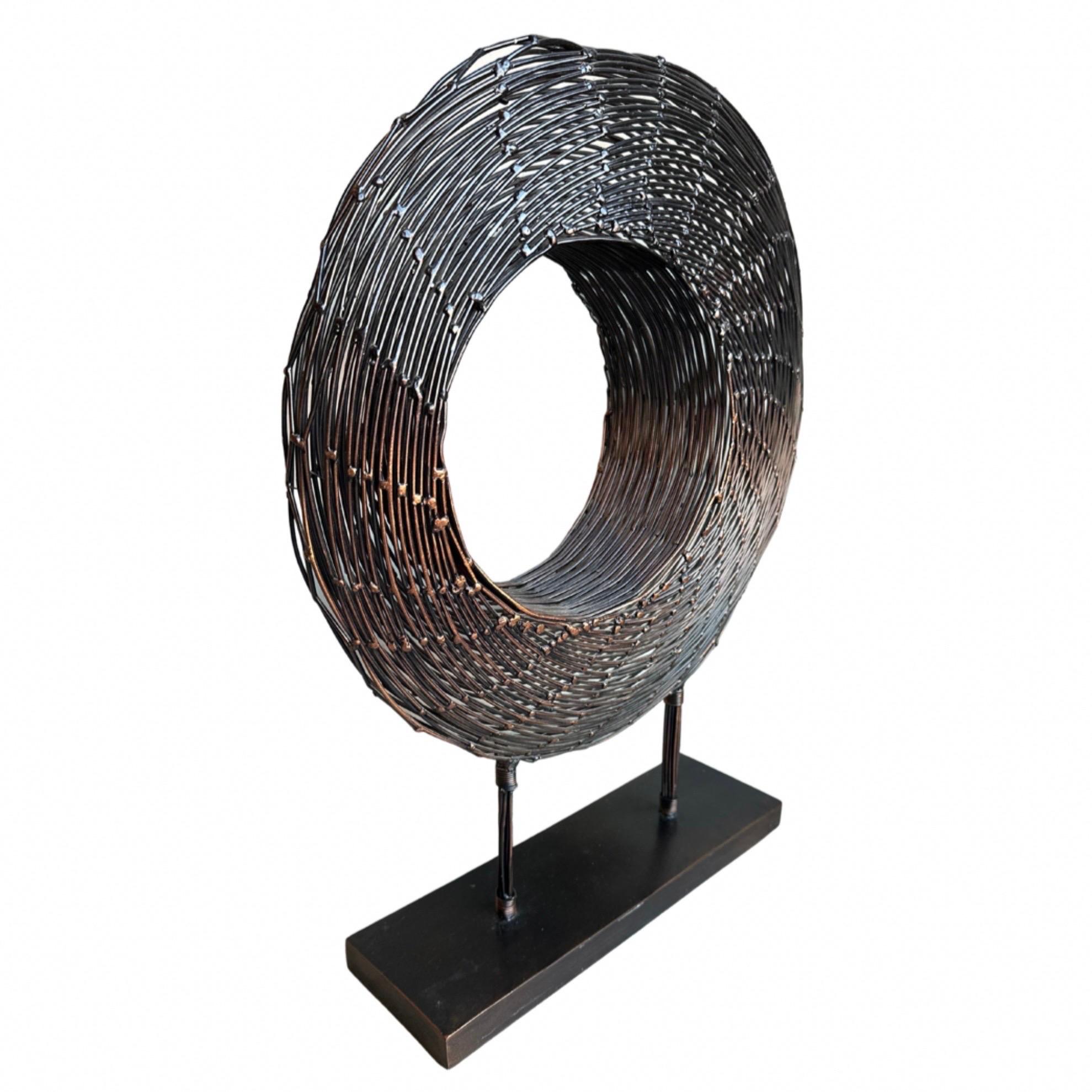 Blackened copper wire spiral sculpture on metal stand. 

 Measures: Height : 25 in

 Width : 20 in

 Base width : 16 in

 Base depth : 5 in

 Base height : 1 in.
 