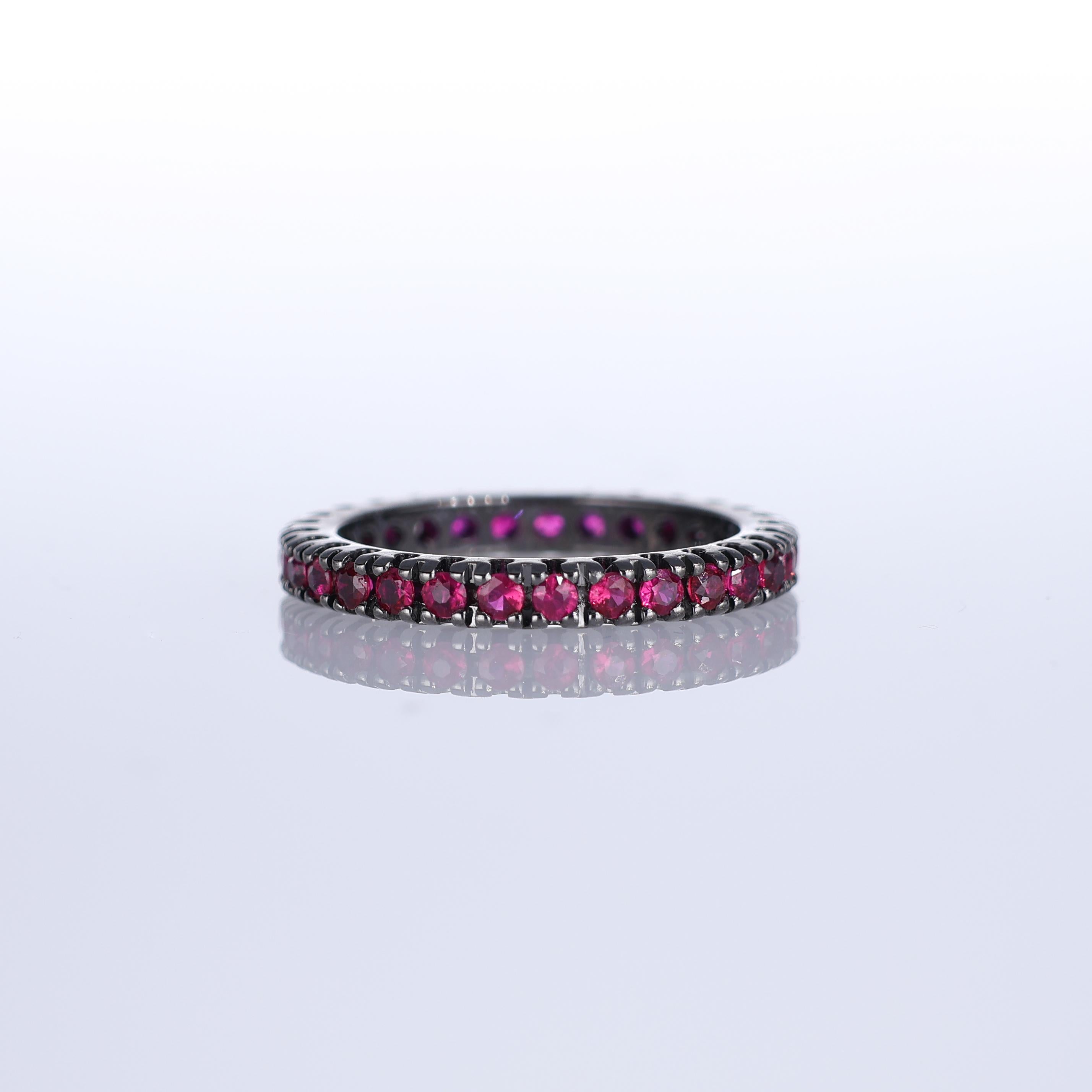 Ce bracelet d'éternité audacieux et sophistiqué en or noirci est orné d'un cercle complet de rubis totalisant 1,03 carats. La teinte rouge profond des rubis contraste de façon saisissante avec le métal foncé, créant une esthétique à la fois