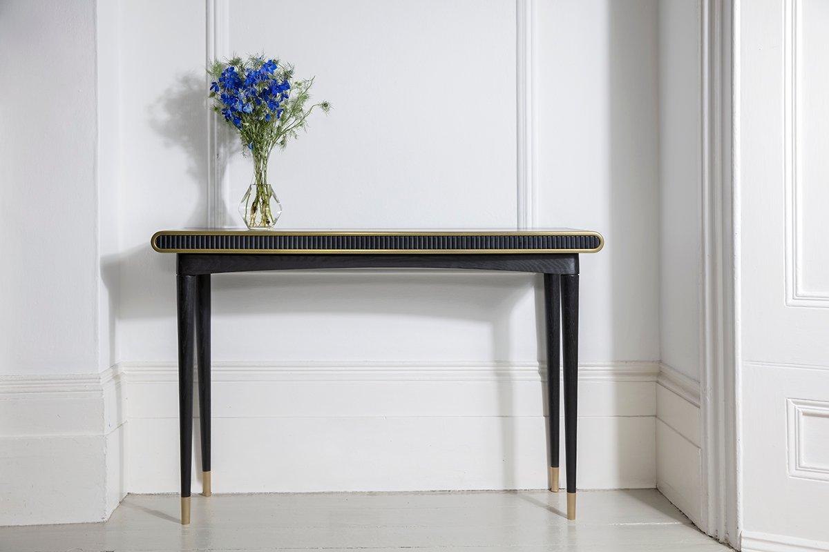 The Gaia console has a hand applied blacked oak frame and infuses both liquid and solid brass details including solid brass 