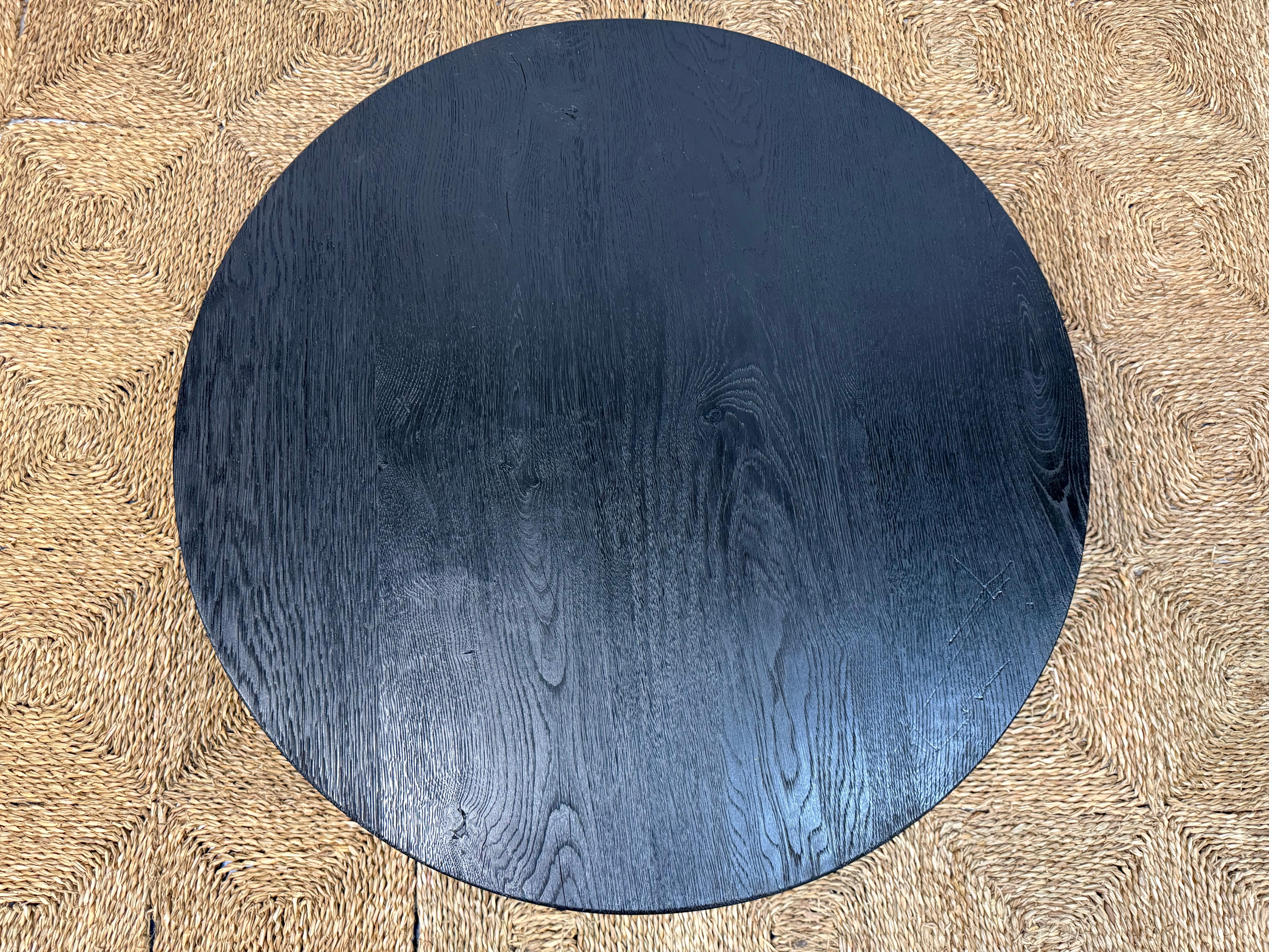 Frappante par sa simplicité et riche en caractère, cette table basse ronde sur mesure est fabriquée à partir de chêne magnifiquement noirci et conçue de manière réfléchie pour élever tout intérieur moderne. Le design est une silhouette moderne