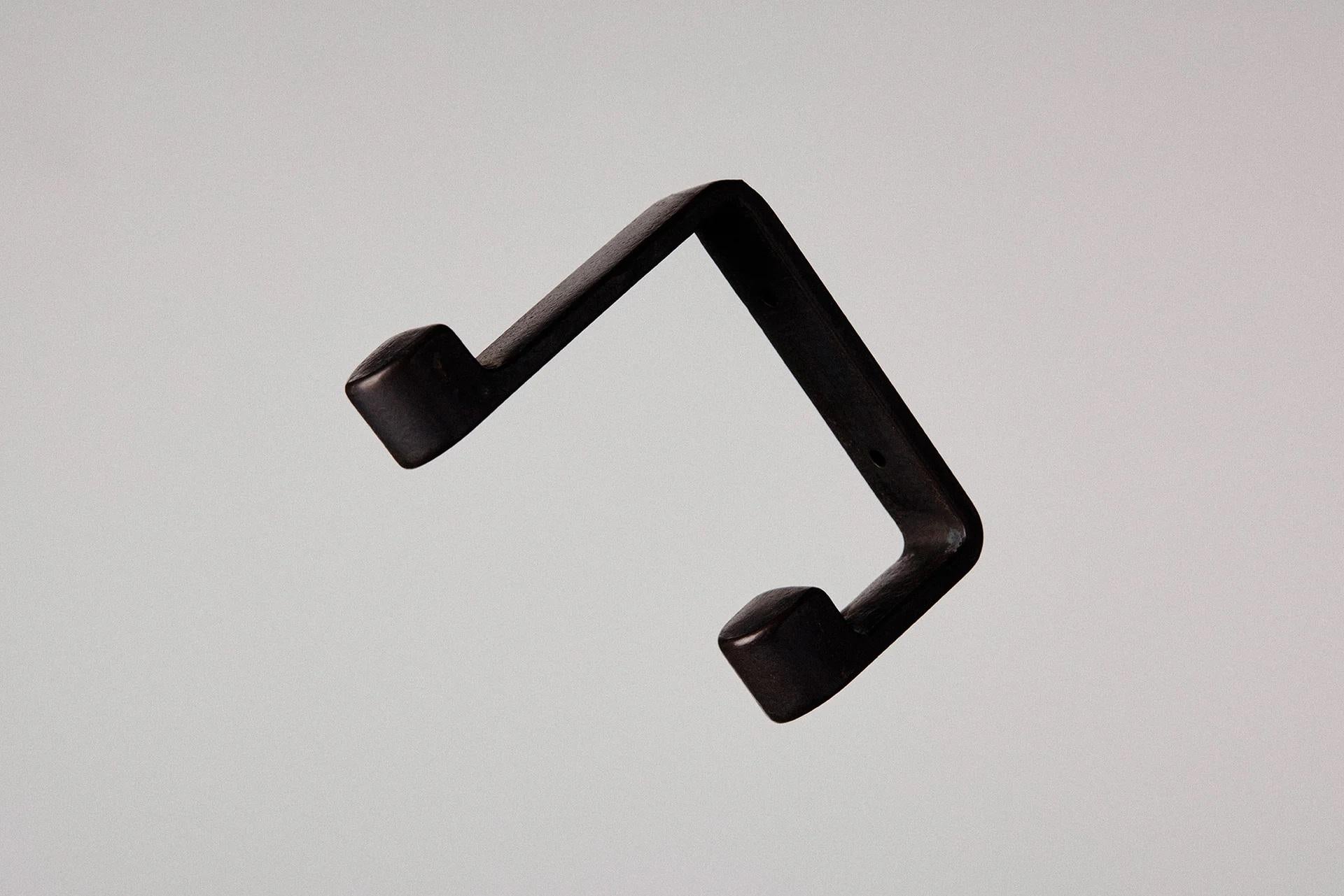 Blackened Ribbon Hook by Henry Wilson
Dimensions: W 2 x D 8 x H 12 cm
Materials: Blackened bronze.

An antidote to last-minute rummaging, the Ribbon Hook features two protruding blocks to accommodate multiple items on a single fixture – hat and
