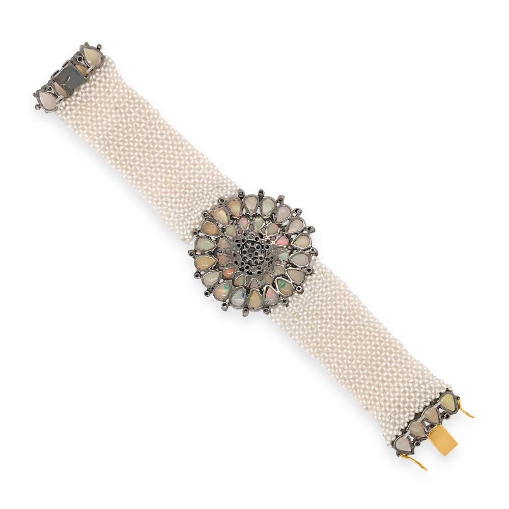 This alluring Victorian antique bracelet is realized in opals, diamonds and seed pearls, weighing 35.83 grams and measuring 18.5cm (7 1/4) long. The artfully designed bracelet is displaying a floral motif plaque consisting of 31 pear-shaped opals