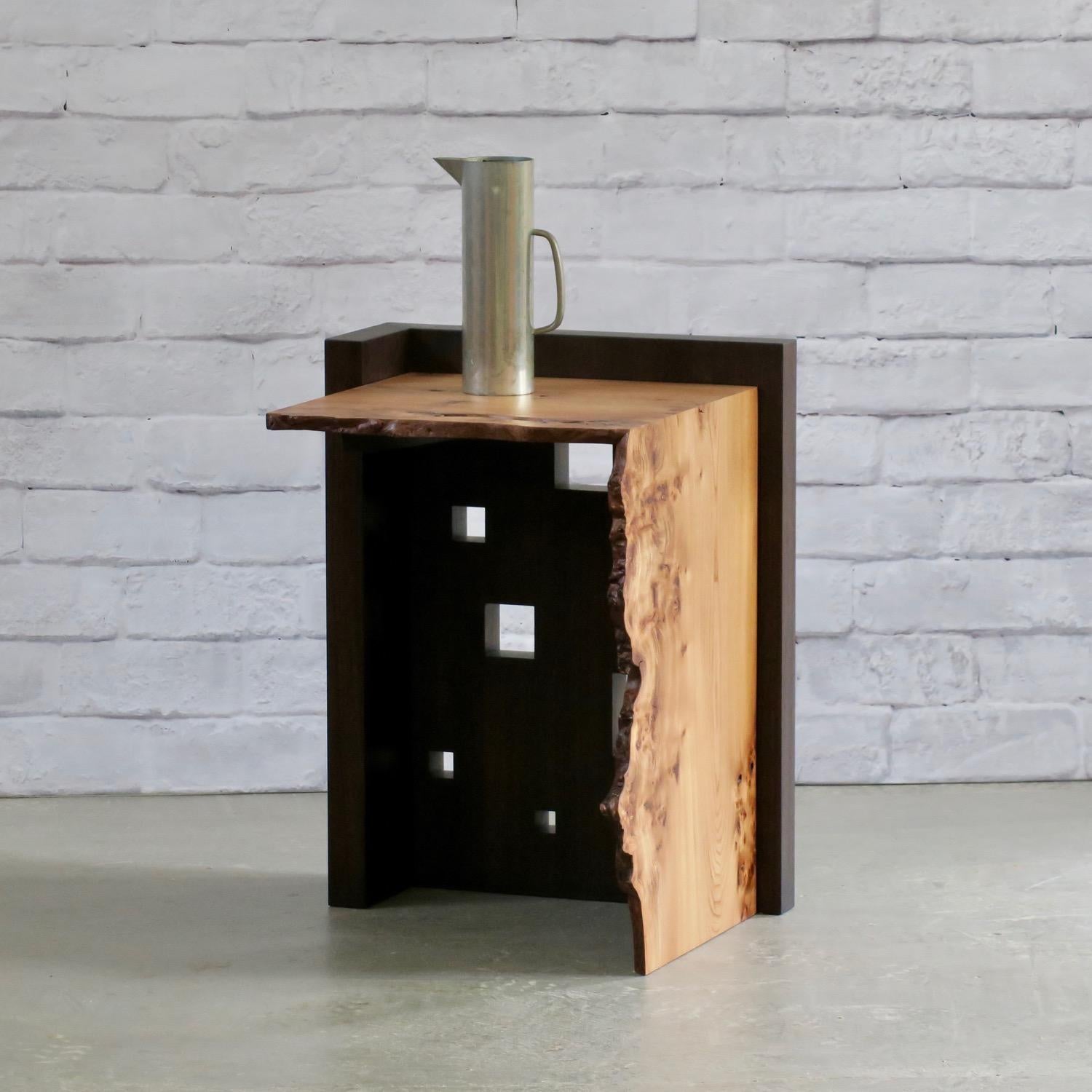The Oriel V side table features a blackened solid walnut base which has been perforated with square 