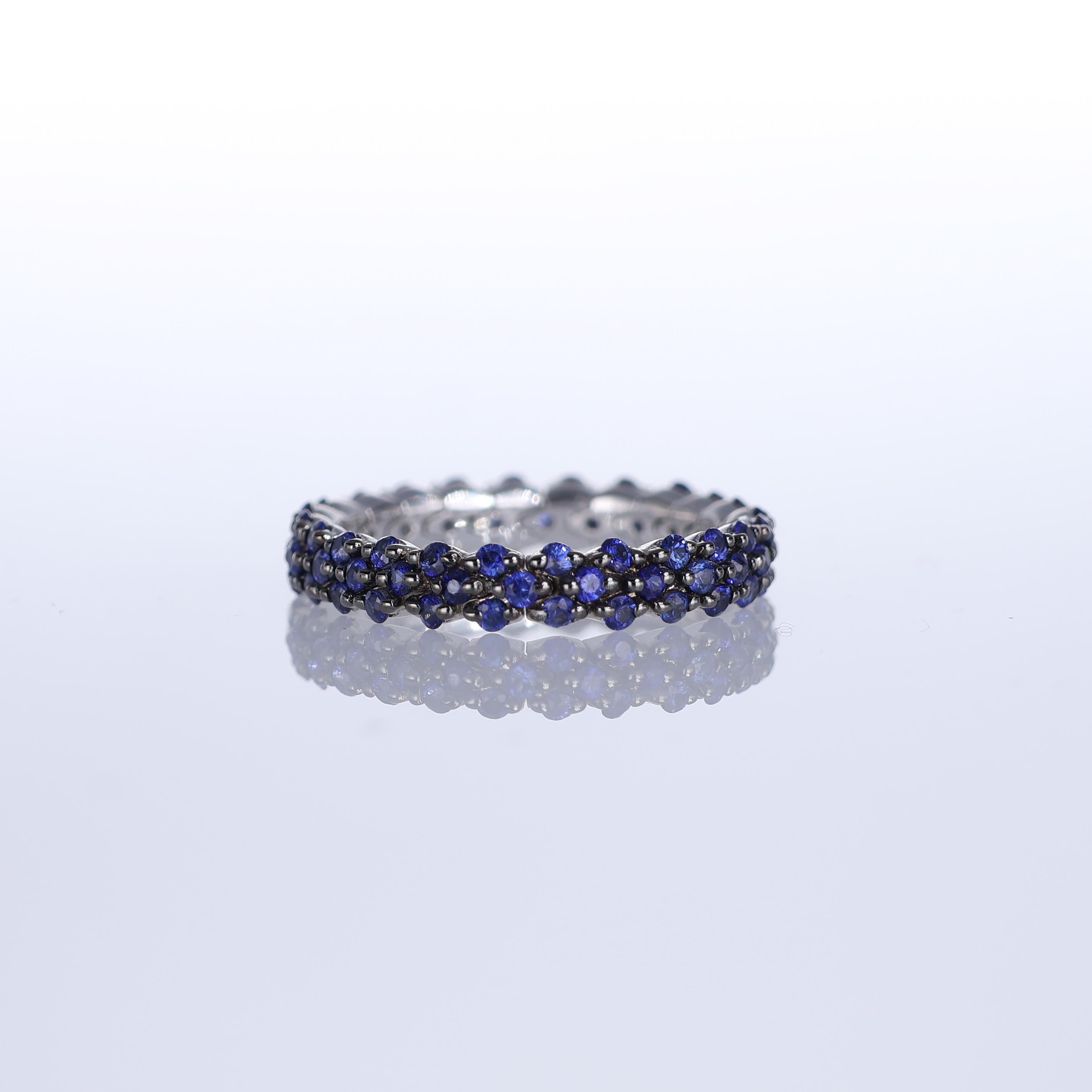 A refined eternity band crafted in blackened 18K white gold, adorned with 1.29 carats of deep blue sapphires. The contrast between the darkened gold and the rich hue of the sapphires creates a striking, modern aesthetic. This elegant yet bold piece