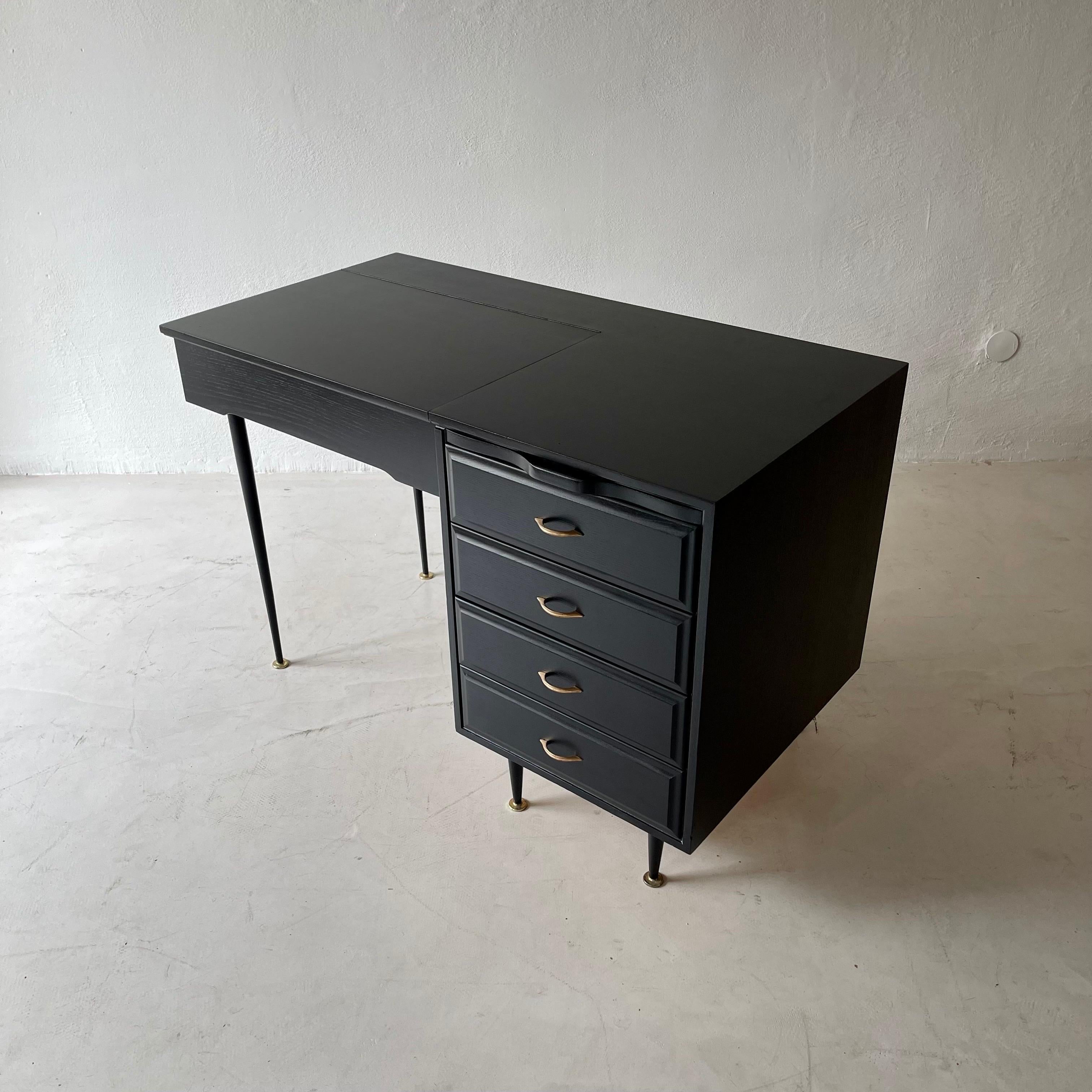 Blackened Writing Desk 1950s with mirror and drawers standing on black metal legs with gold colored details.