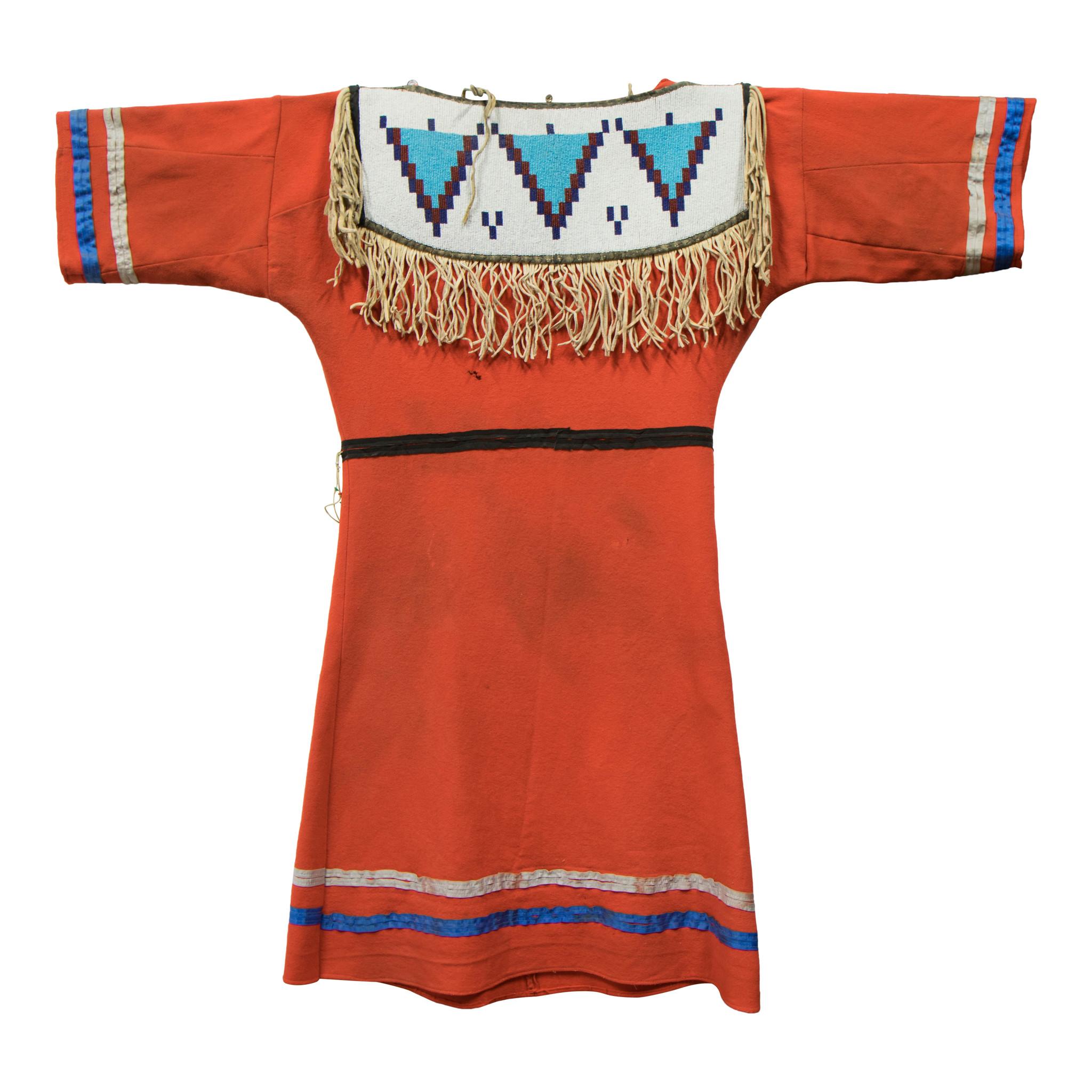 Blackfoot dress of red Stroud. Estimated 1920s. Beads on panels both sides carried over from 19th century.

Period: 1920s

Origin: Blackfoot

Size: 40
