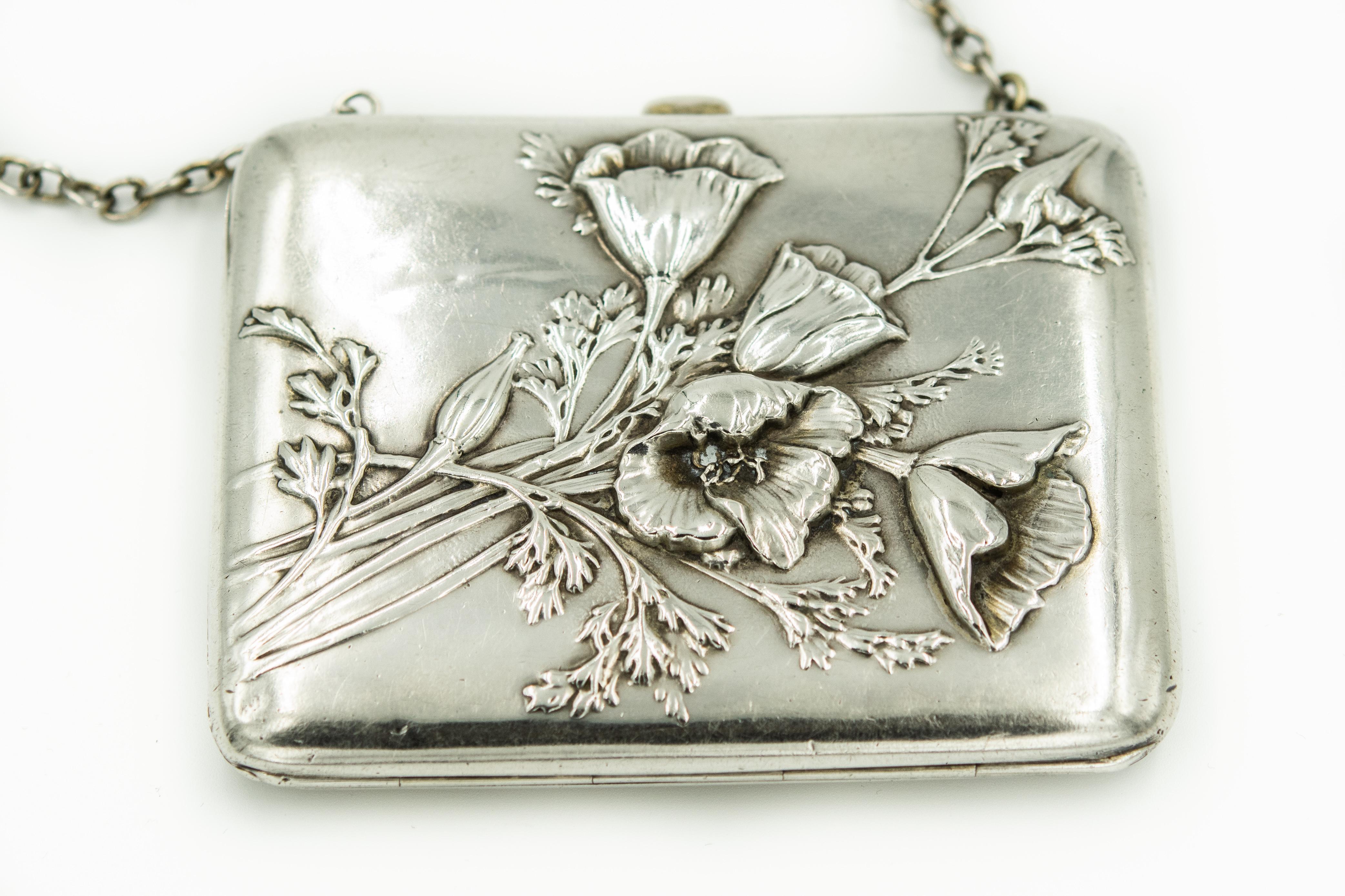 Beautiful art nouveau (1890-1910) sterling silver card case made by American Silversmith R. Blackinton & Co.  The front of the case features raised repousse flowers and the back of the case is monogramed in script (letters difficult to determine). 