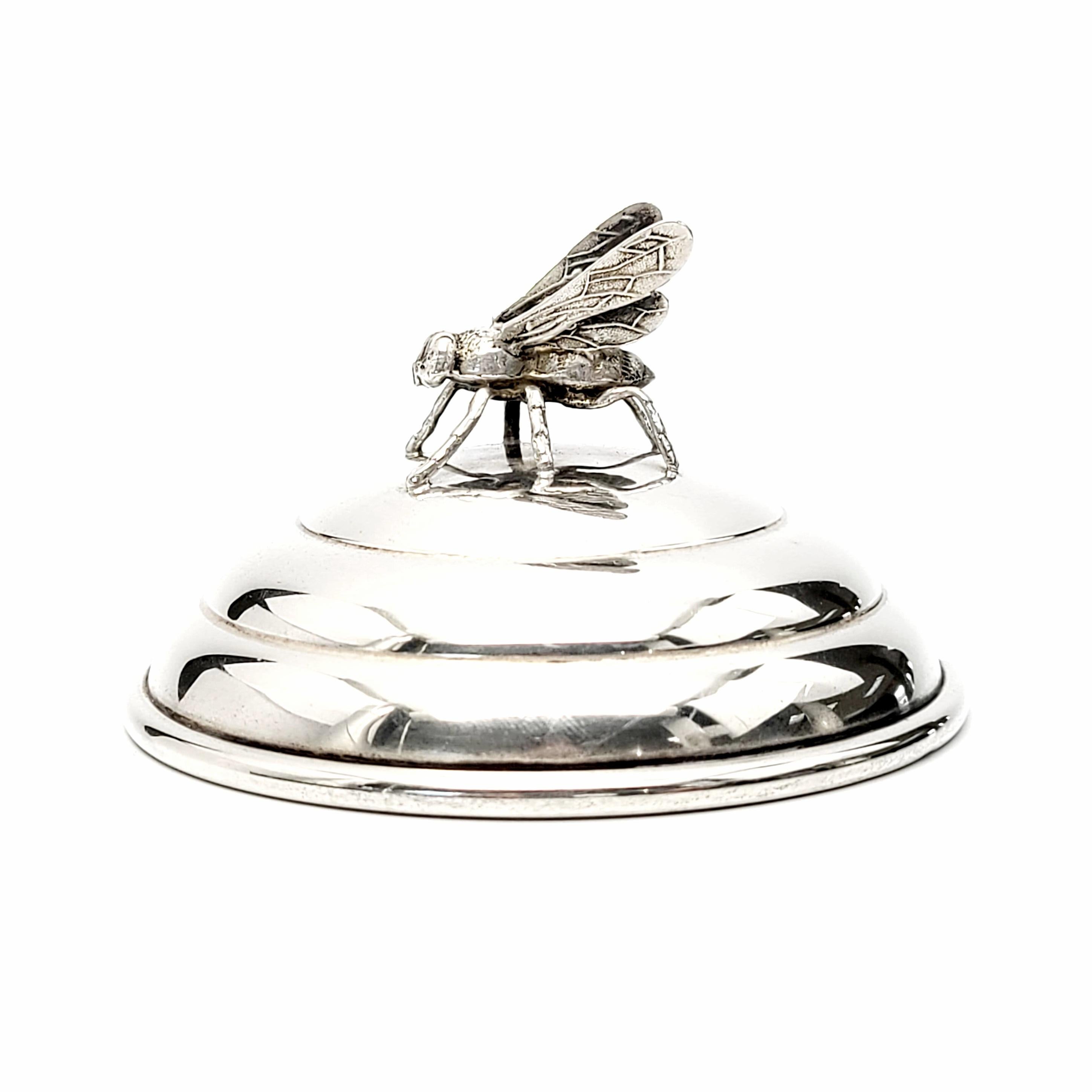Antique sterling silver honey bee jar lid by R Blackinton & Co.

This lid is meant to top a glass honey jar. It features ribbed design to resemble a hive with a small hole for a spoon or honey stick. Topped with an intricately detailed honey