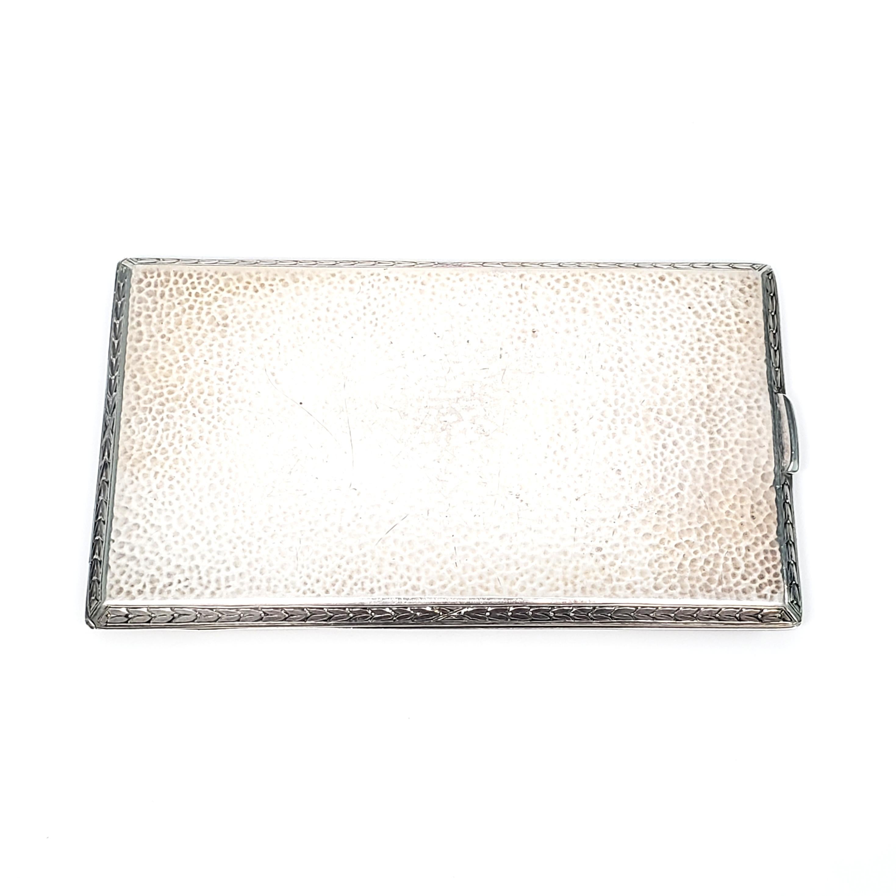 Antique sterling silver large/long cigarette case by R Blackinton & Co.

This beautiful piece features a hammered design on both sides with a leaf-like frame design and a gold gilt interior with a spring arm. It has a well functioning push button