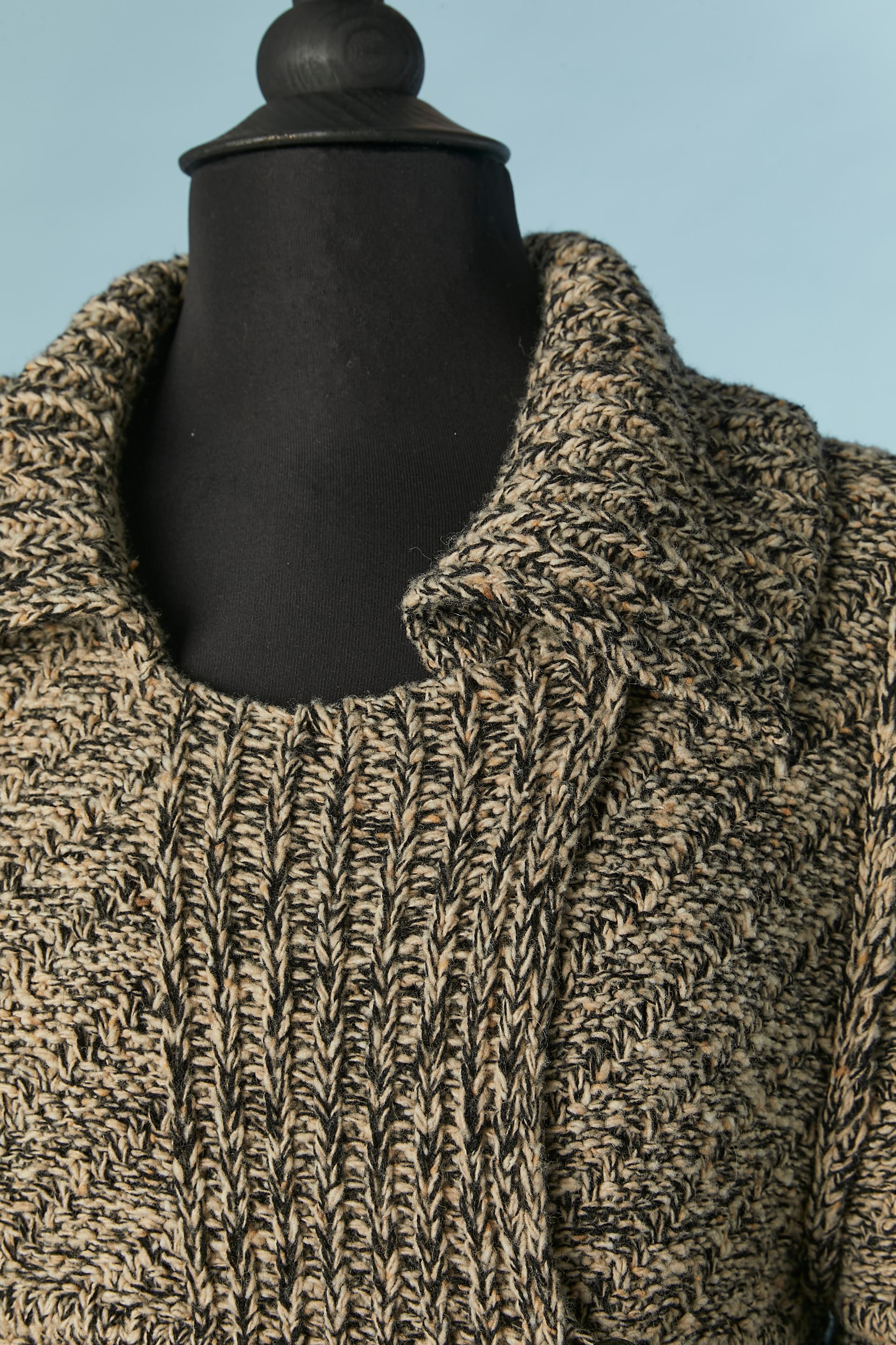 Manteau en maille chinée noir et blanc cassé  avec pochette de chaque côté. Composition du tricot : 96% laine, 4% cachemire. 
Bouton et boutonnière, poches sur les deux côtés. 
TAILLE 40 (Fr) M/L 