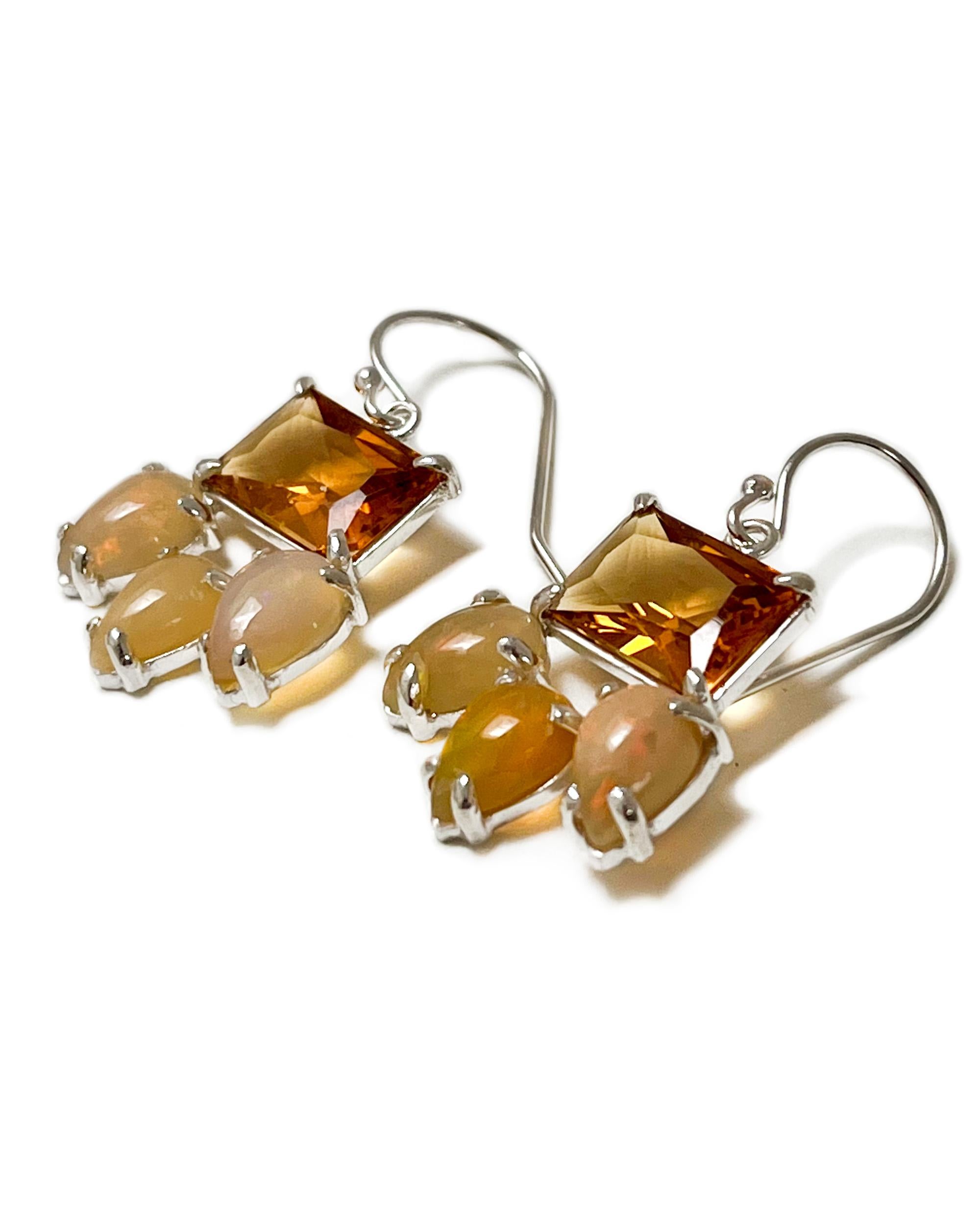 Intention: Pretty Little Thing

Design: Emerald cut orange quartz stabilizes three small, smooth opals on these charming dangle earrings. 

Style Suggestion: ﻿Wear these feminine earrings with something frilly, or pair with more orange accents.