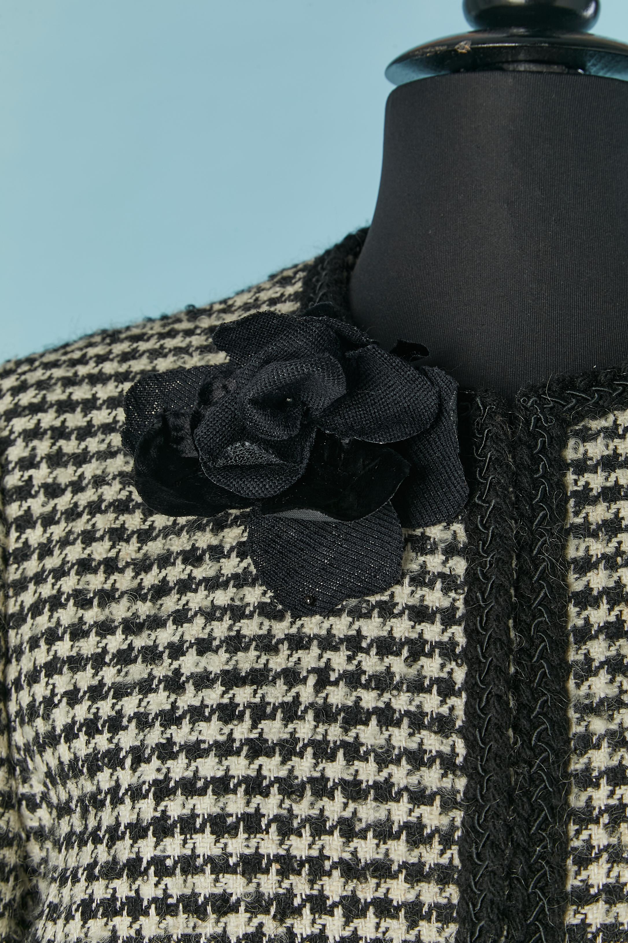 Black&white tweed and Prince de Galles pattern skirt-suit with black braid edge on the jacket. Shoulder pad. Hook&eye closure on the middle front. No fabric composition tag but the lining is probably in acetate or rayon. 
SIZE of the jacket :42 (Fr)