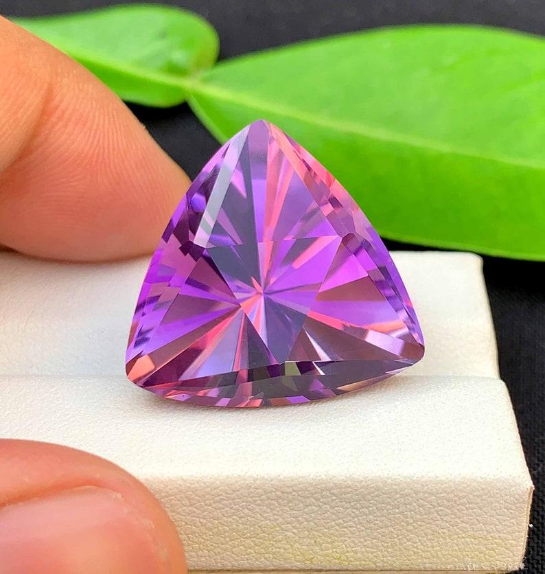 This exquisite Amethyst gemstone from Brazil showcases the timeless beauty and mystique for which the Quartz family is celebrated. Expertly fashioned into a striking fancy cut, the stone reveals captivating facets that enhance its rich and velvety