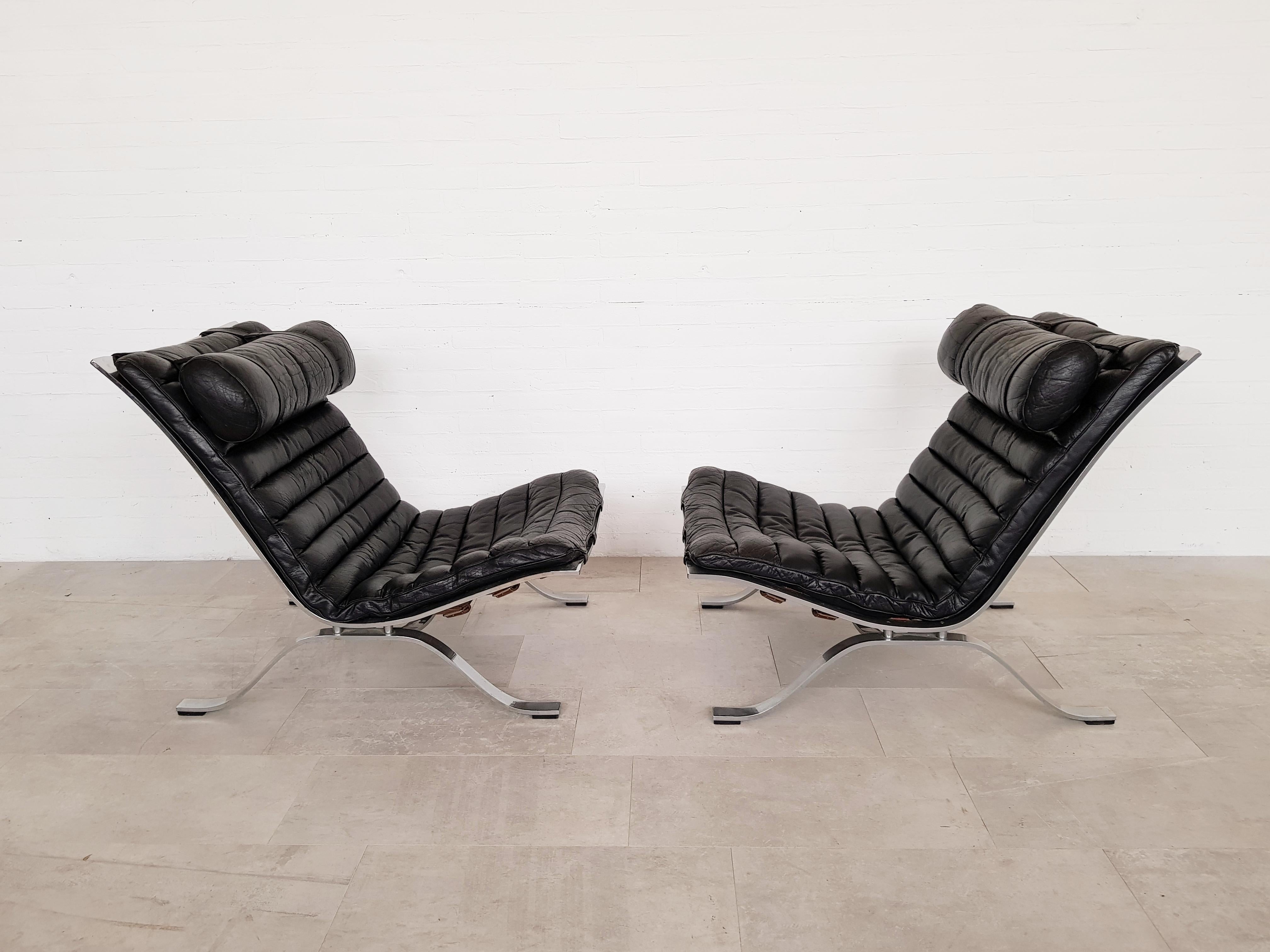 The easy chair Ari is Norells most well-known and appreciated piece, designed in 1966. Loose cushions upholstered in black patinated buffalo leather. Satin chromed flat steel base. Produced by Norell Møbel AB.