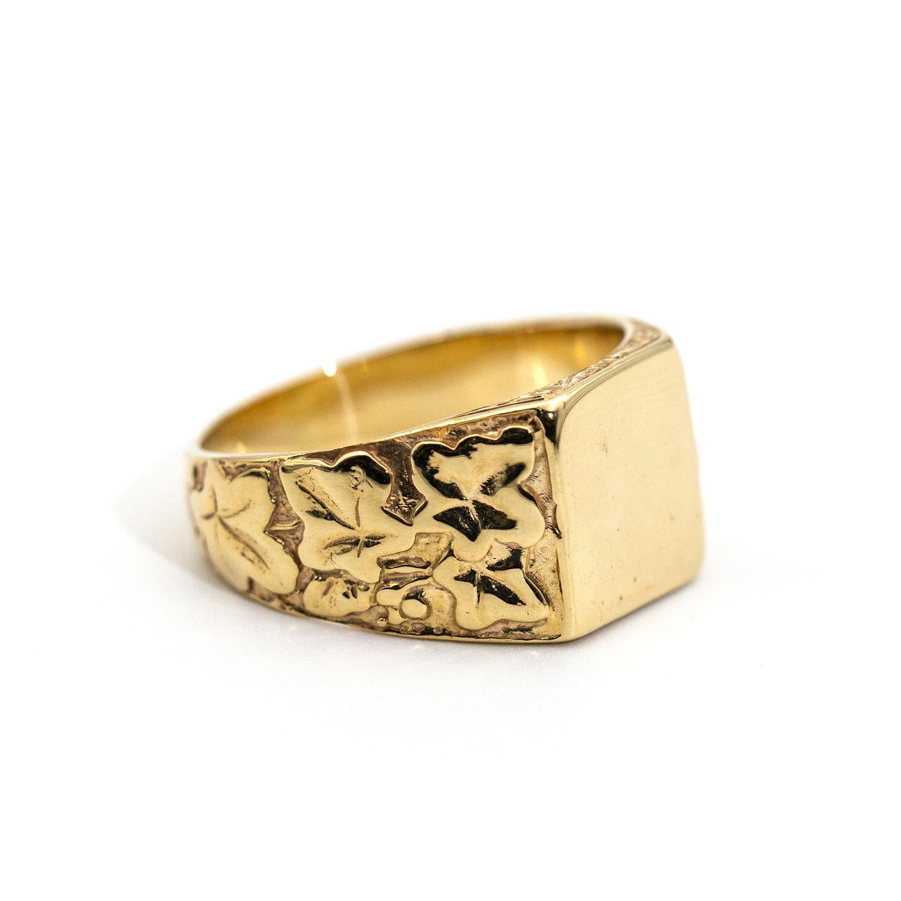 Forged in 9 carat yellow gold is this handsome mens signet ring featuring unique leaf patterned shoulders that flow up to a flat square top ready for engraving your own family crest or initials if you so please. We have named this dapper ring The
