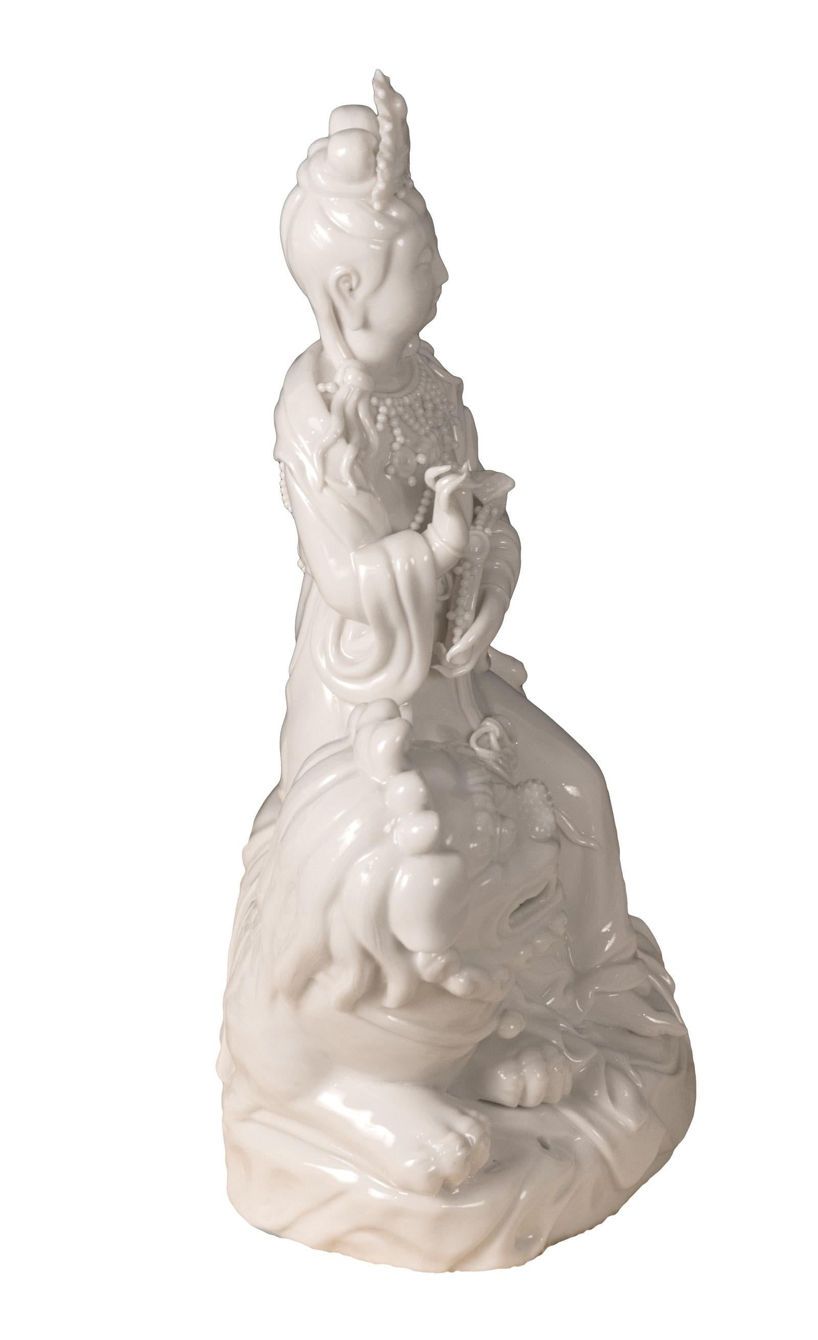 Blanc de chine (Dehua) porcelain figural group of Quan Yin on Foo Dog or Temple Lion (circa 1970),

China

Measures: 11.25 x 8 x 4.5.