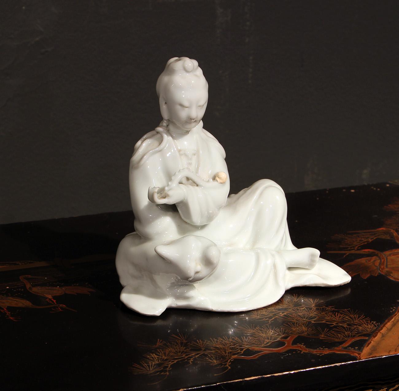 Chinese blanc de chine of a porcelain Quan Yin in a sitting position dressed in a soft robe, holding a scepter  Emperor's Ruyi.