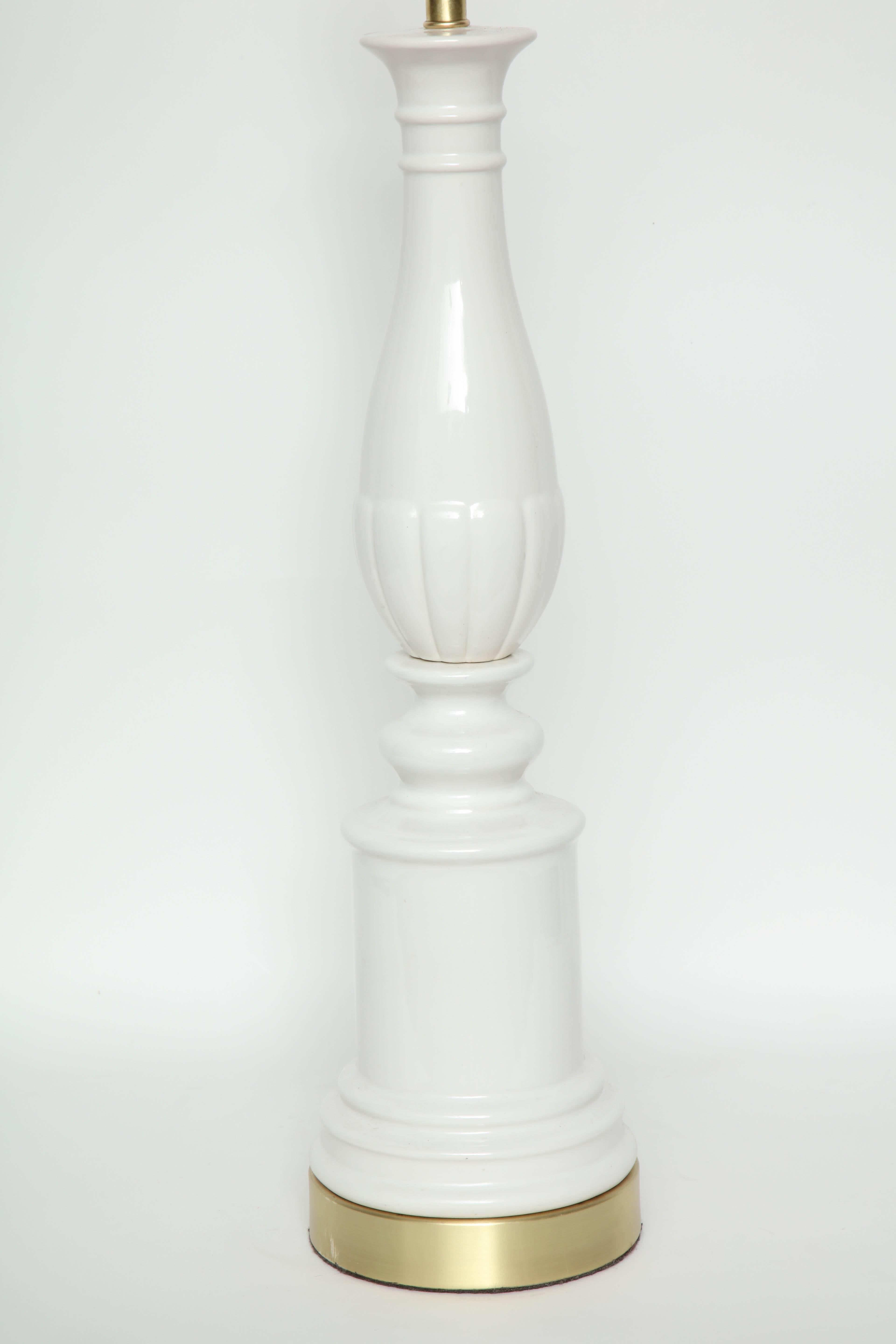 Paire de lampes balustres stylisées en porcelaine Hollywood Regency à glaçure ivoire reposant sur des bases en laiton satiné. Recâblé pour une utilisation aux USA, ampoules 100W max.

Le corps de la lampe mesure 23 pouces.