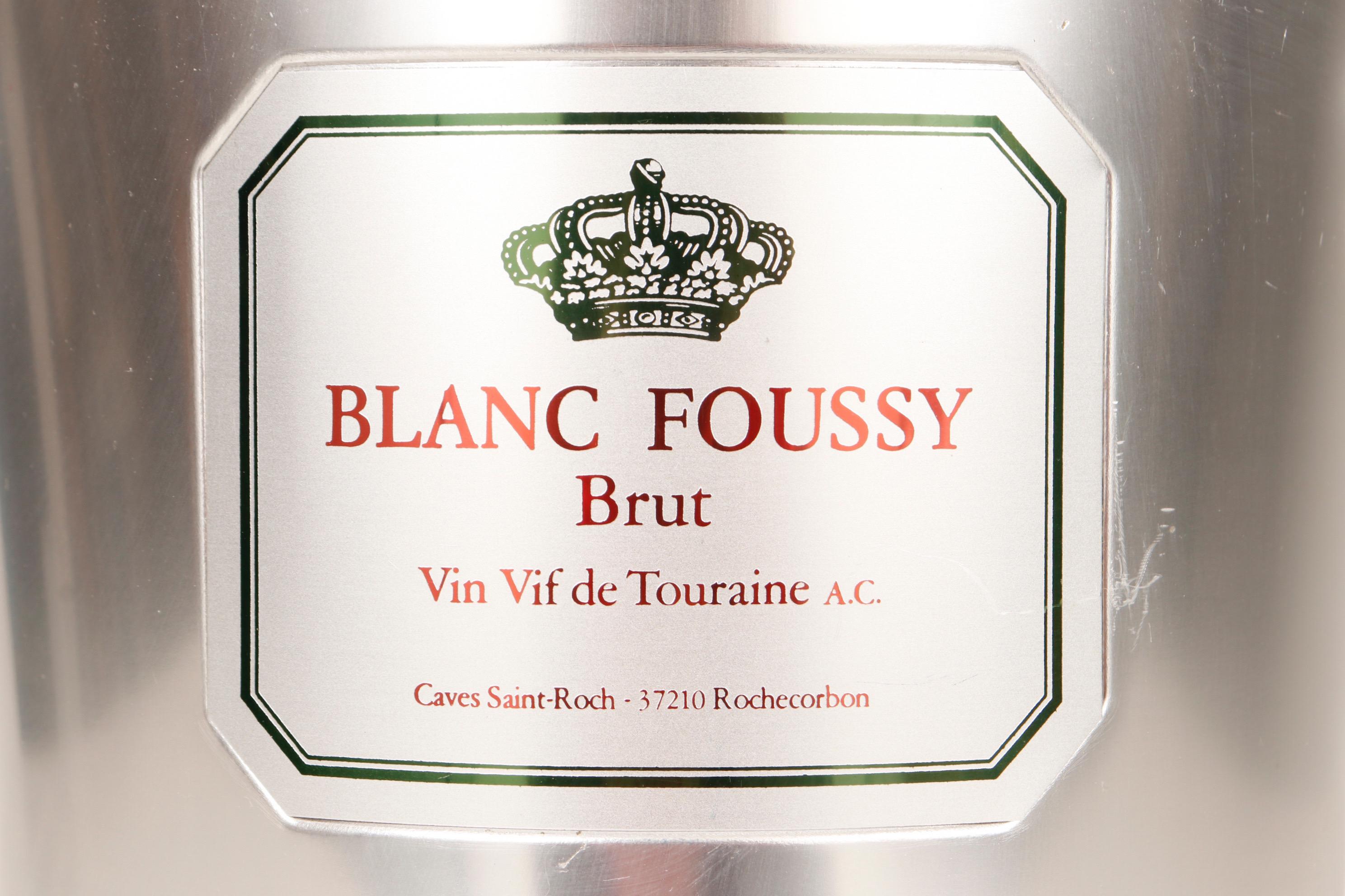 A Blanc Foussy Brut Champagne bucket. Made of aluminum, the bucket has a round pull handle at each side. In front is a plaque which reads “Blanc Foussy Brut Vin Vif de Touraine A.C. Caves Saint-Roch - 37210 Rochecorbon”.
