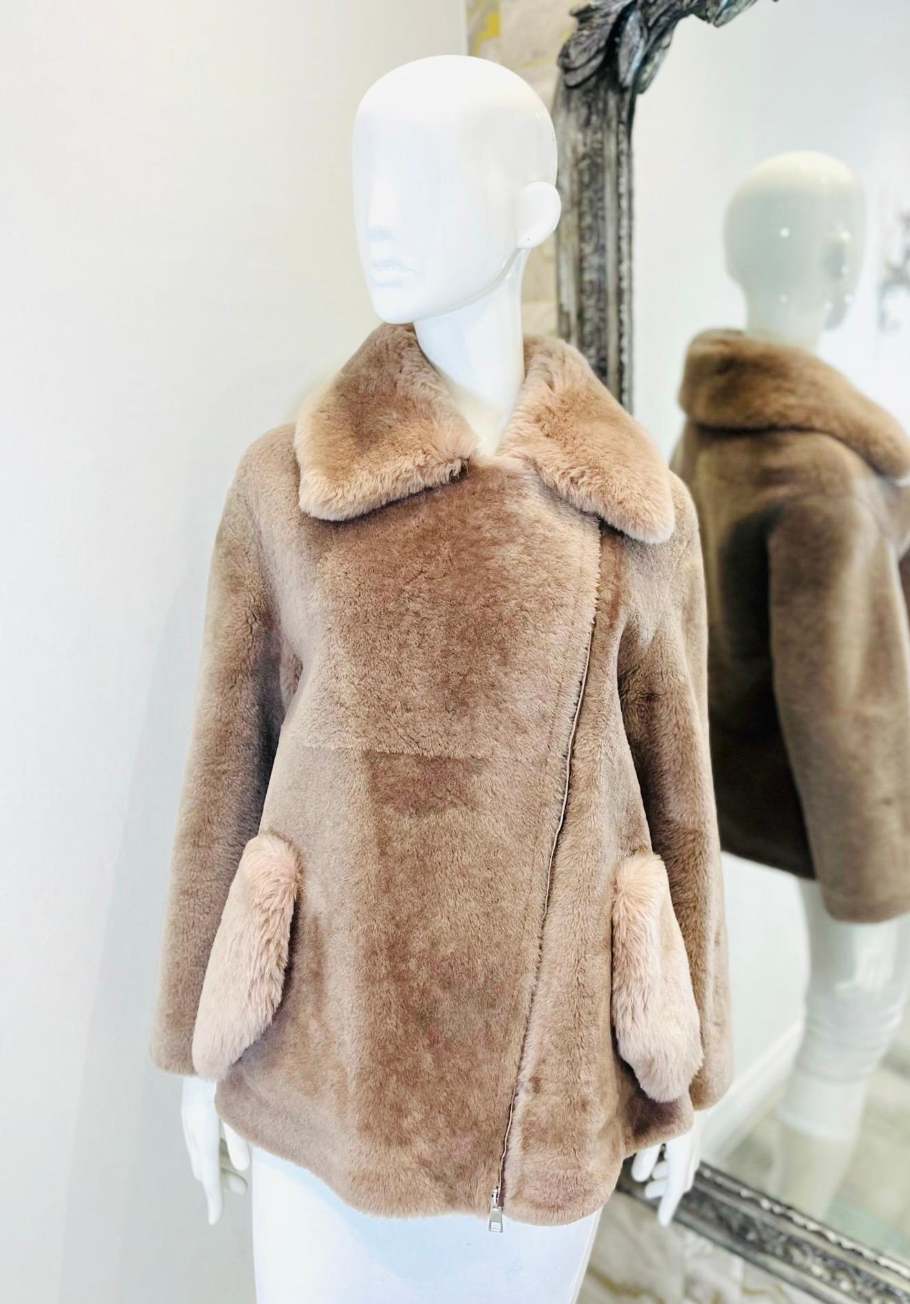Blancha Sheepskin Teddy Coat

Pinky beige Italian-made coat crafted from plush shearling.

Detailed with oversized collar and side flap pockets, featuring asymmetric zip fastening.

Styled with lambskin leather interior.

Size – 38IT

Condition –