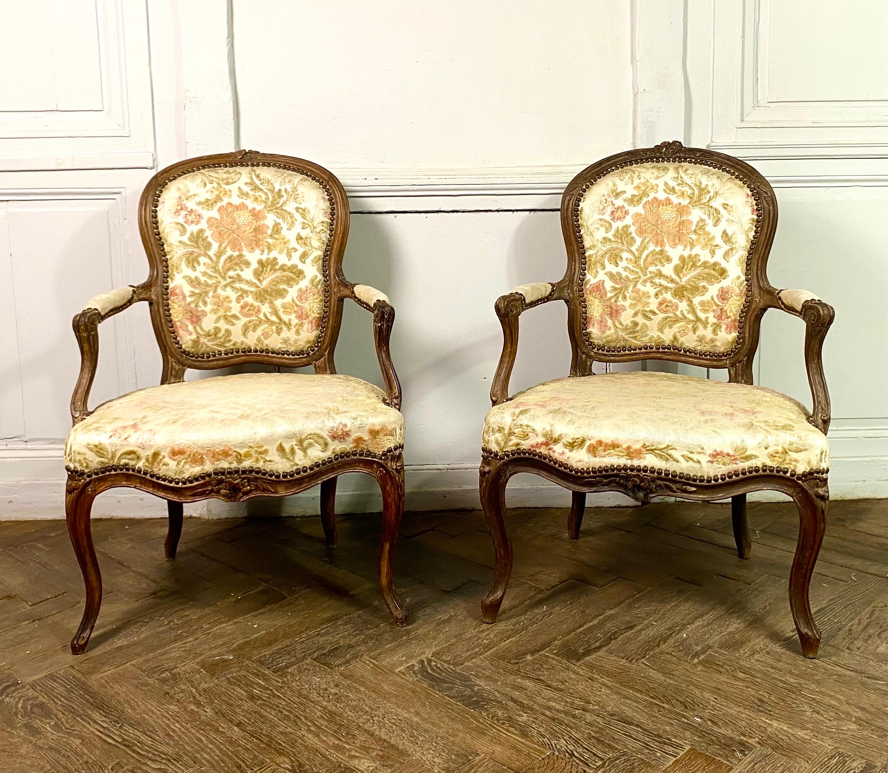 Magnificent pair of convertible armchairs with violin backs in molded and carved walnut from the Louis XV period. one of which is signed Blanchard. The armchairs have an elegant decoration of flowers and foliage.
One of the two armchairs is stamped