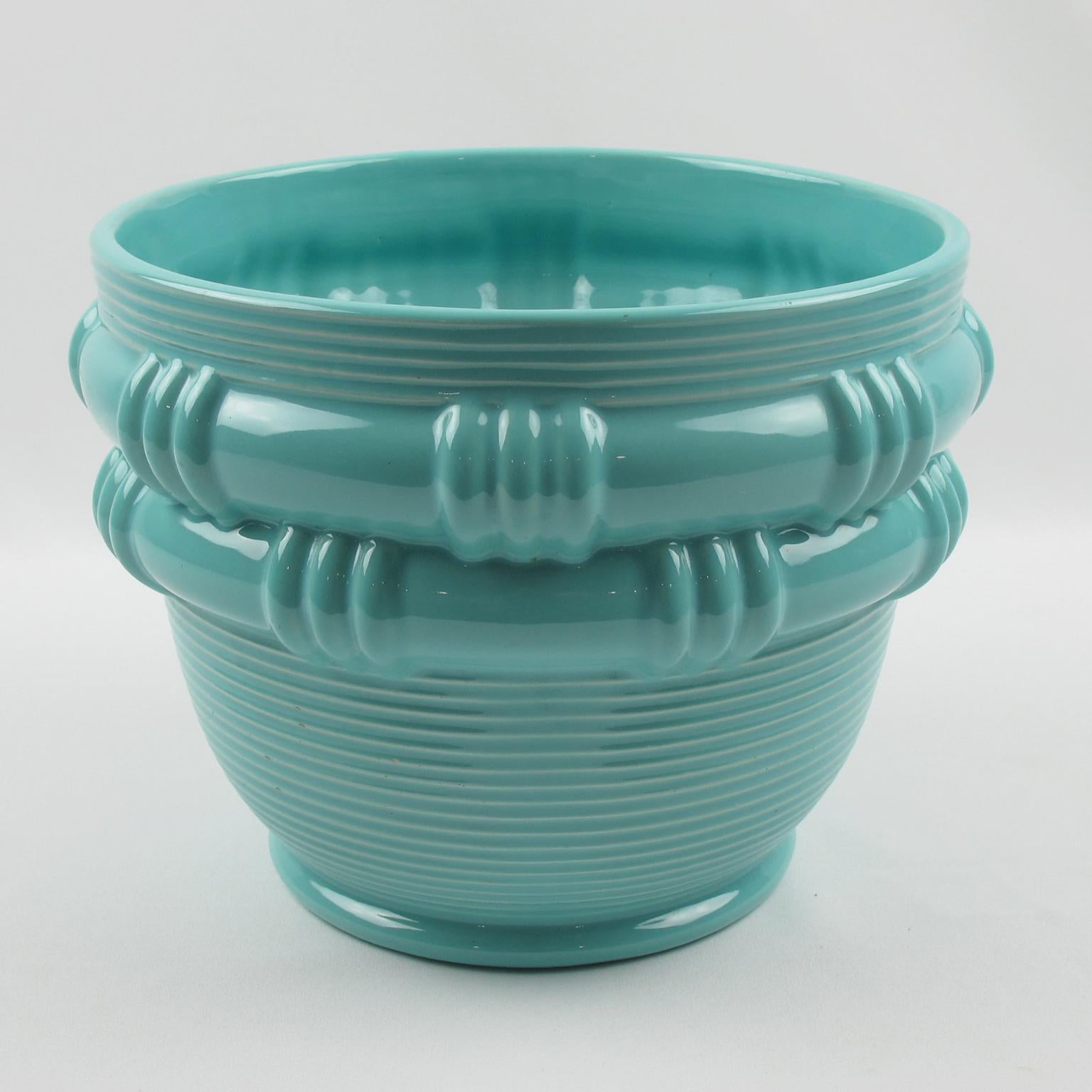 La ceramista Blanche Letalle ha realizzato questo splendido vaso o fioriera in ceramica degli anni '50 per la Faiencerie Saint-Clement, in Francia. Il pezzo vanta un'incantevole smaltatura turchese con un motivo a cesto. Blanche Letalle è stata una