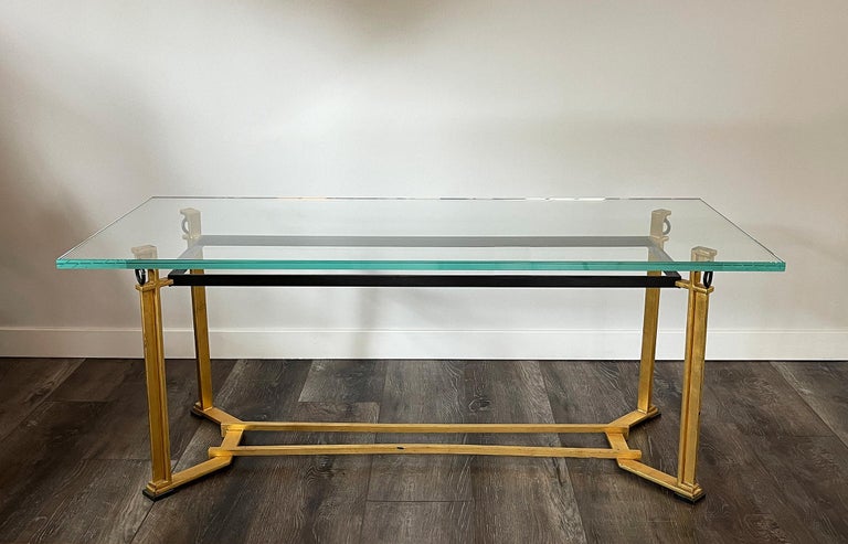 Blasset Jean & Guggiari André: Worked for Chanaux & Jean Michel Frank.

France, circa 1950s.

Very unique coffee table in gilt iron and glass. The interior frame of the table, under the top, the rings and the bases of the legs have been