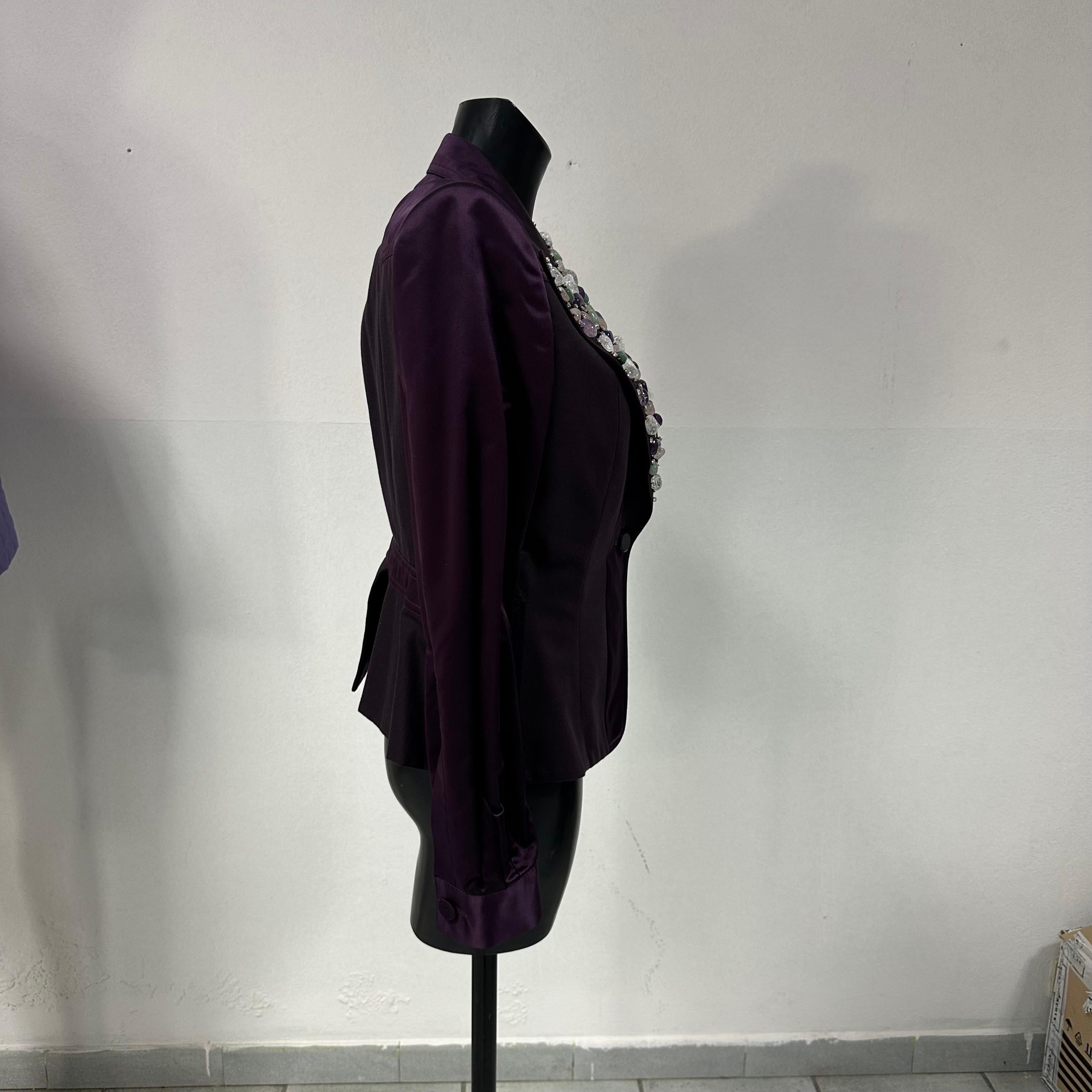 La giacca viola con pietre di Gianfranco Ferrè è un capo da collezione imperdibile perché rappresenta l'essenza della moda italiana. Questo capo è stato creato per una donna forte e sicura di sé, che non ha paura di esprimere la propria personalità