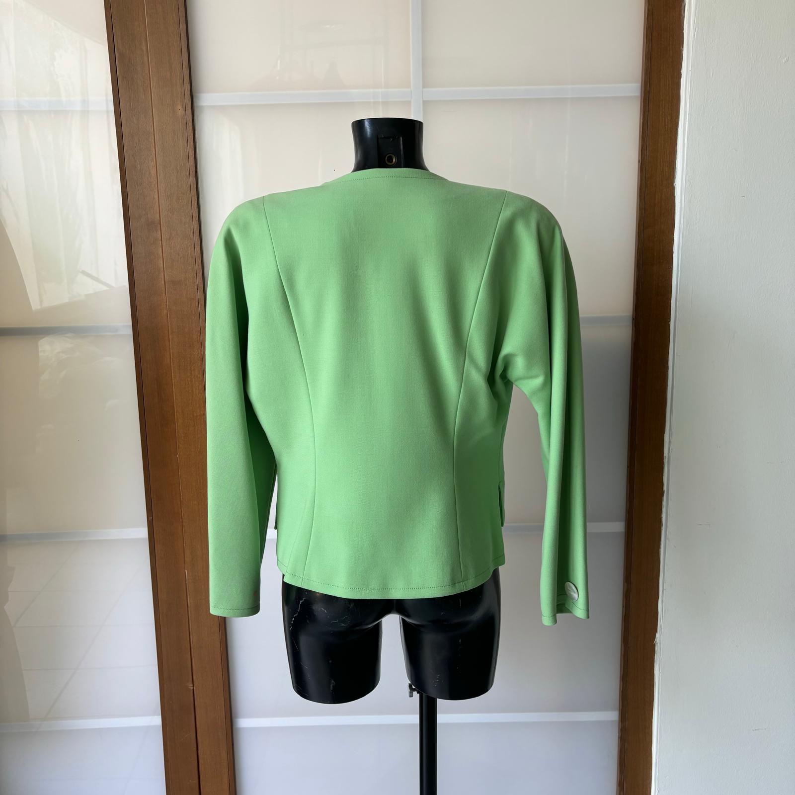 Blazer Genny verde vintage de los años 80 en excelente estado, cierre con un solo botón, modelo  short ligeramente sobredimensionado con hombros raglán adecuado para tallas de la pequeña a la grande
Composición de lana, forro interior