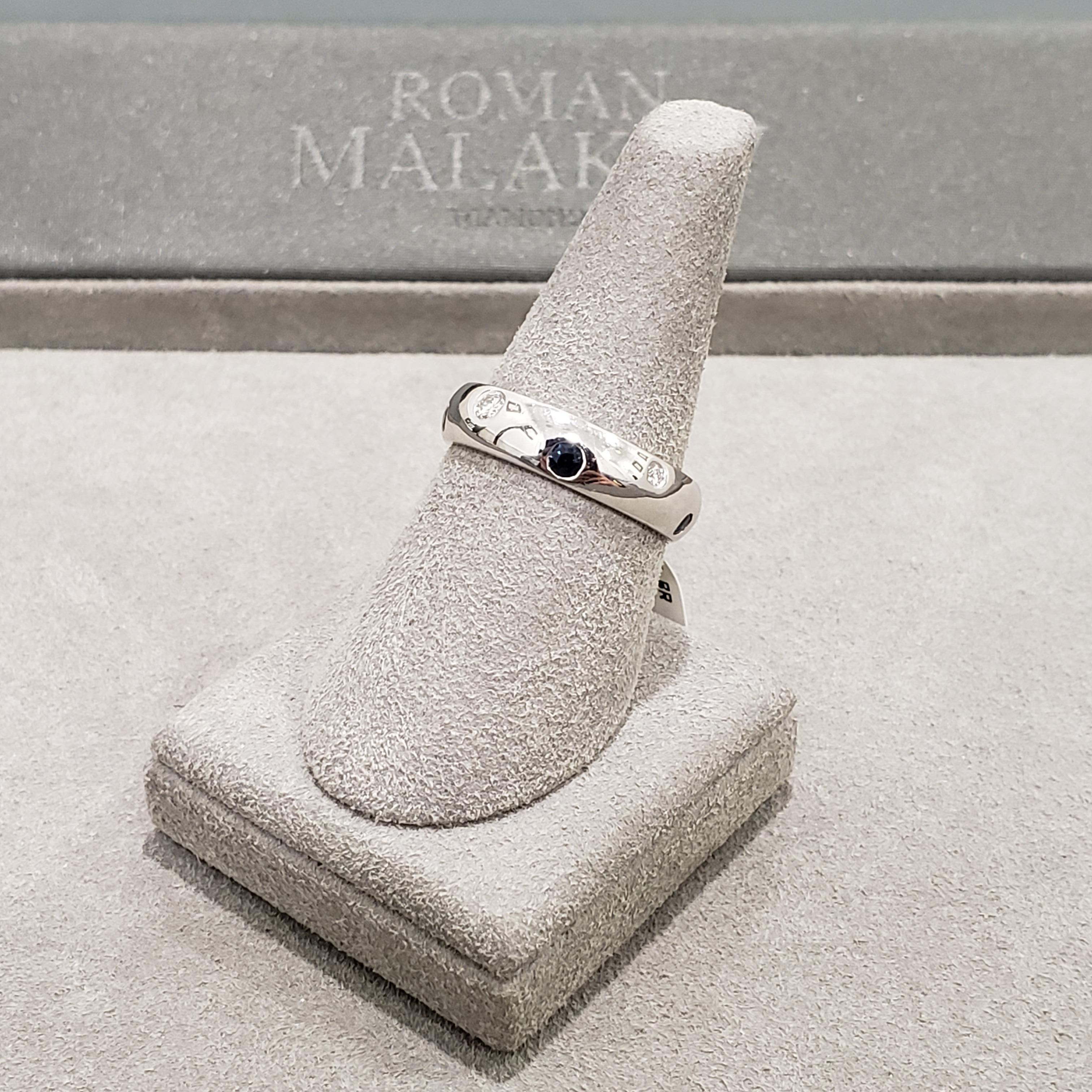 Showcasing a mix of round diamonds and blue sapphires, set flushed in a staggered and rounded Etoile design. The diamonds weigh 0.21 carats total and the sapphires weigh 0.23 carats total. Made in 18 karat white gold. Size 6.75 US.

Roman Malakov is