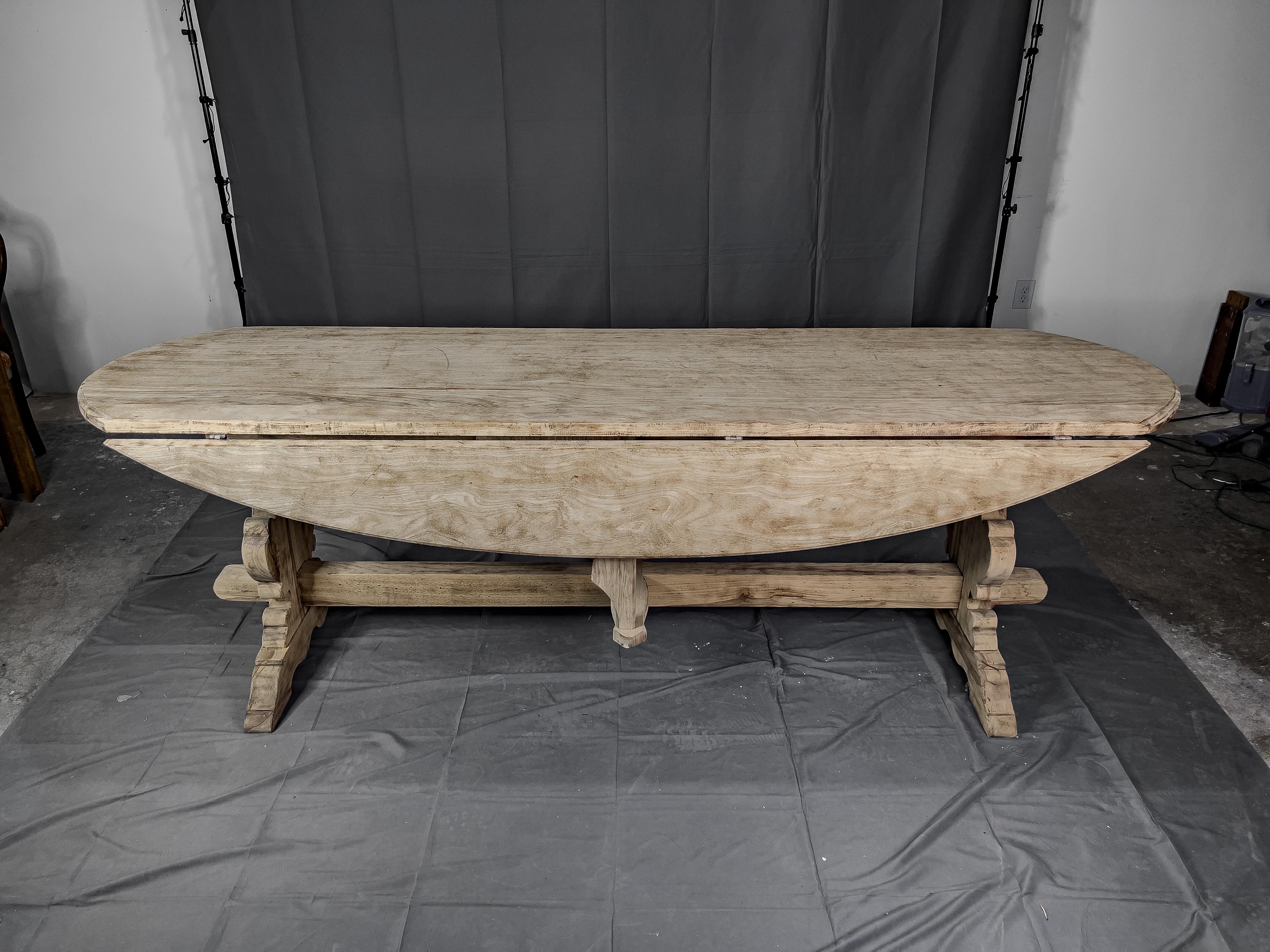 Bleached 19th c. French oak drop leaf trestle table with 2 leaves. The leaves are supported by a 