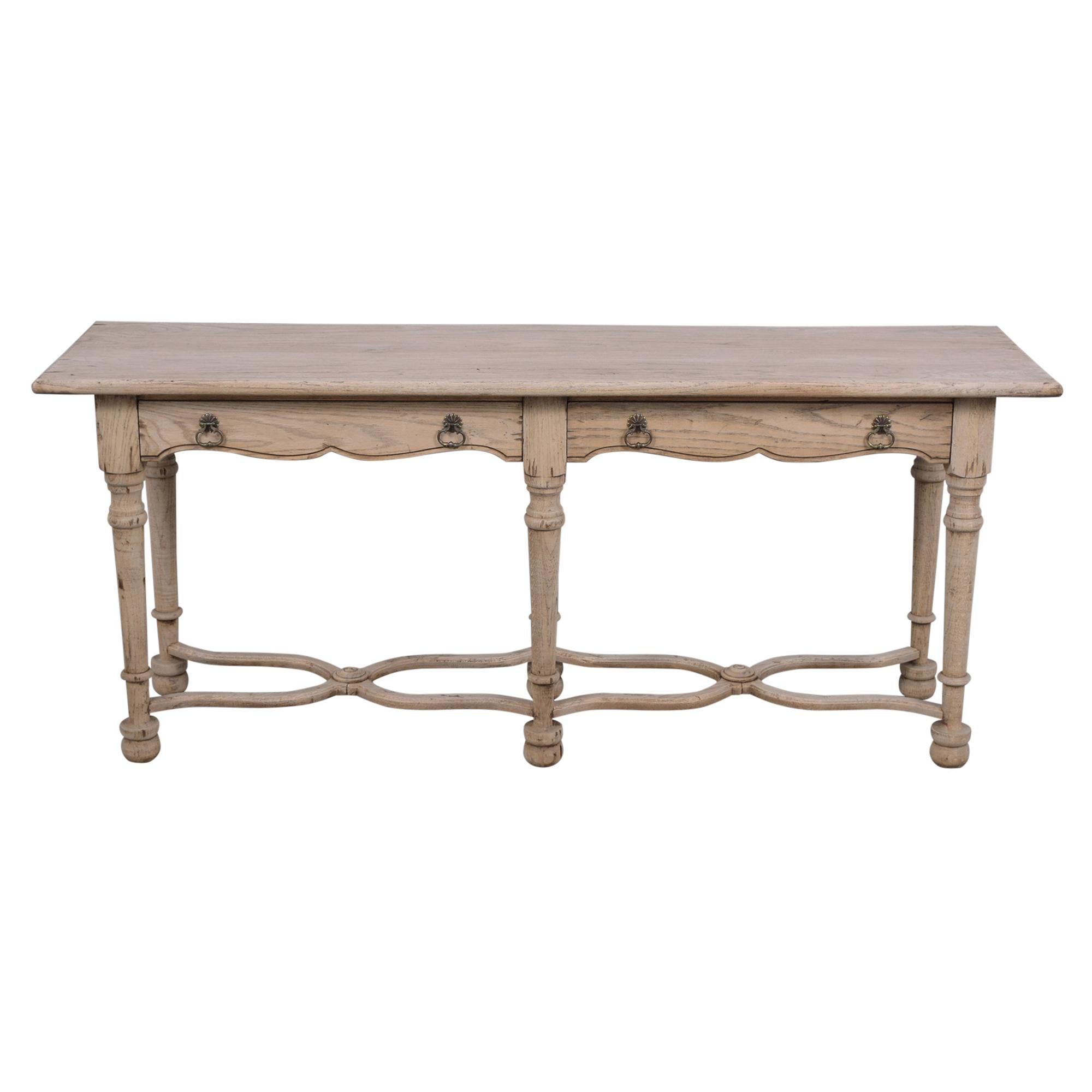 This beautiful vintage Spanish-style console table is in great condition hand-crafted out of oak wood with a newly bleached wood finish and has been professionally restored. The vintage sofa table has a large solid wooden top, two large pull-out