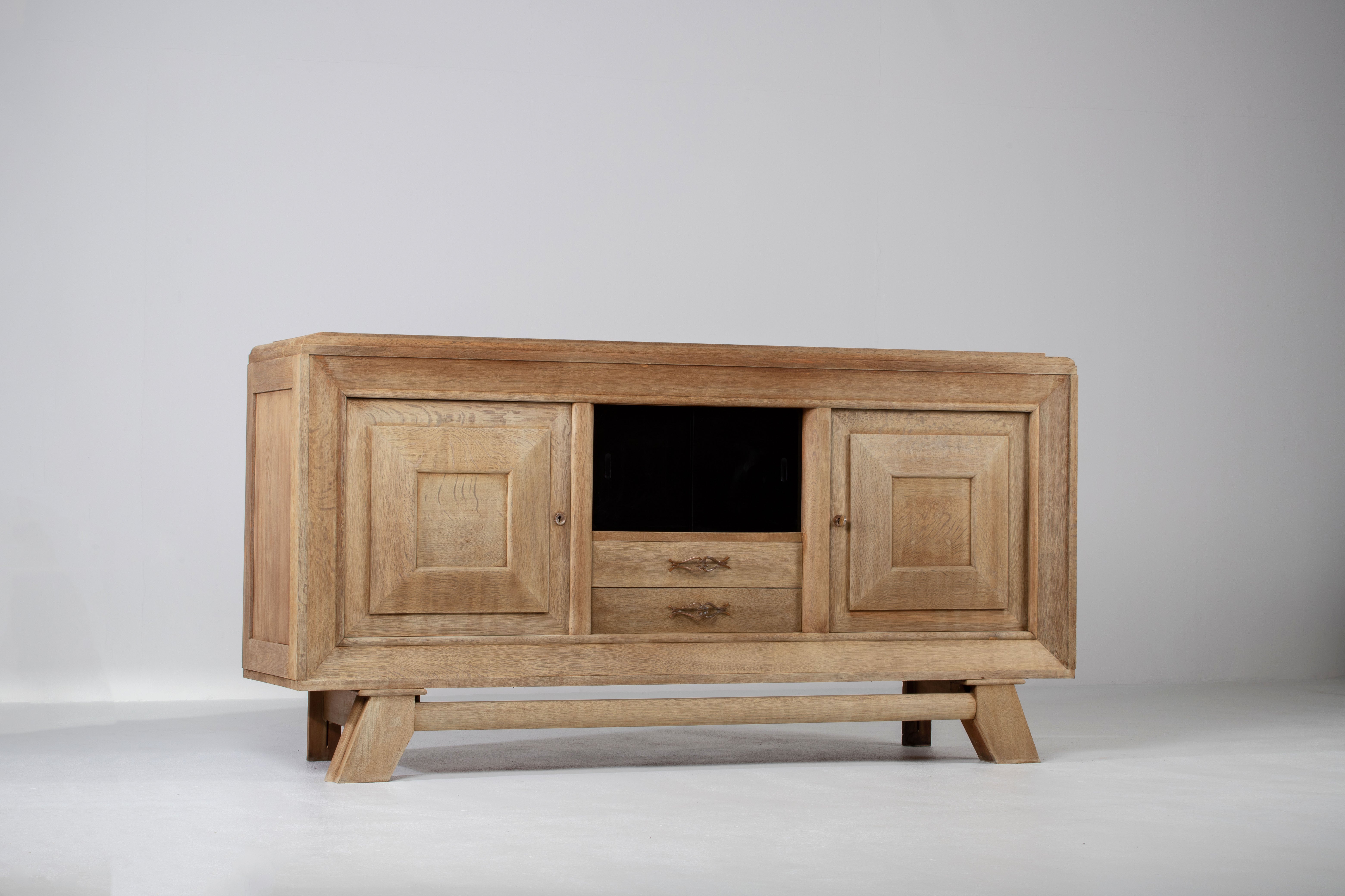 French Art Deco bleached sideboard, credenza in oak. The sideboard features stunning Oak sanded wood grain with a stunning patina. It offers ample storage, with shelves. The top is covered with marquetry.
The sideboard is in excellent original
