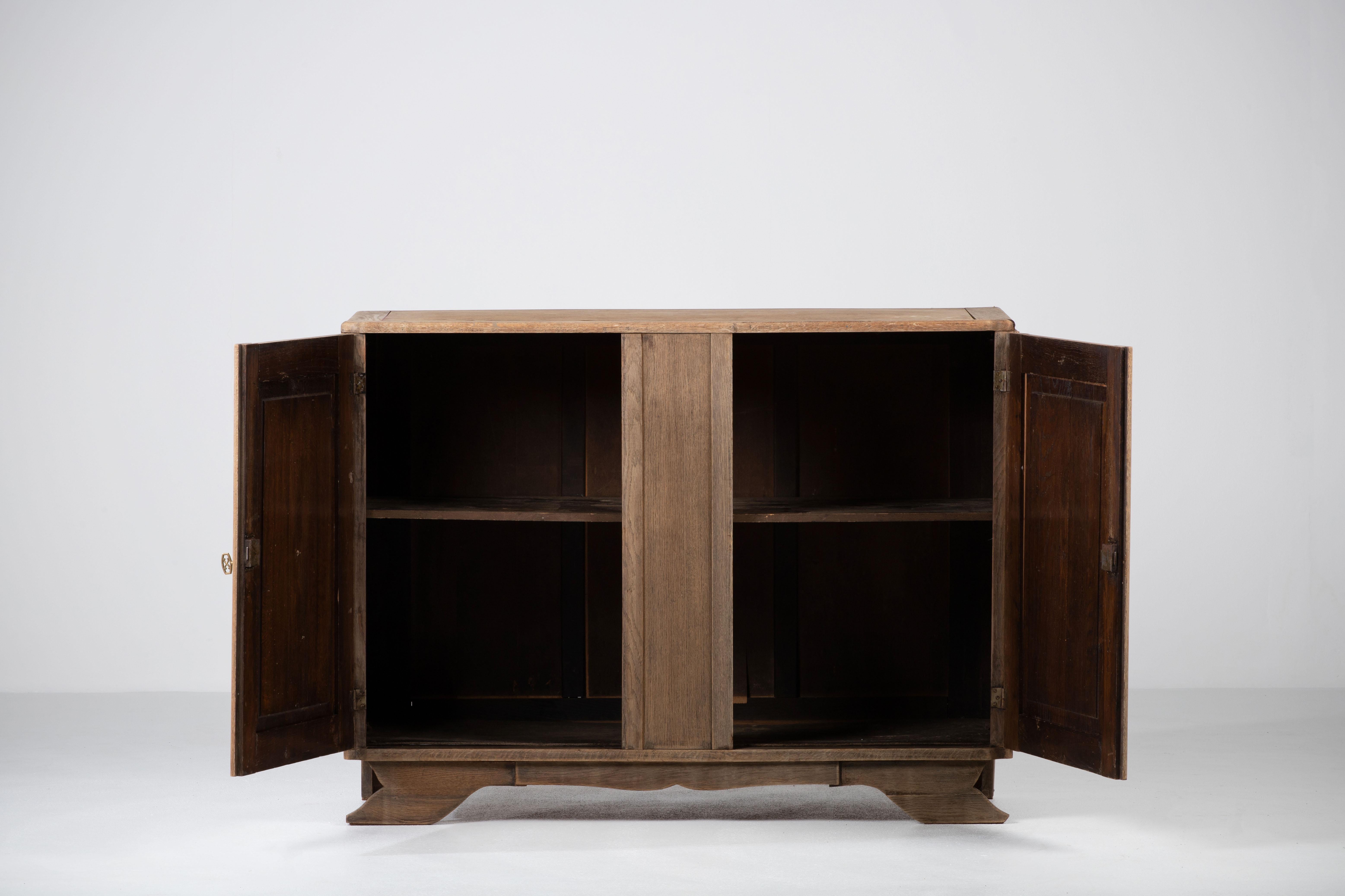 A sideboard/credenza presumably by Charles Dudouyt. 
France, c1930s.
Consists of two doors providing shelves storage compartments.
Signature graphic design doors make this piece really stand out.
The sideboard is in good original condition, with