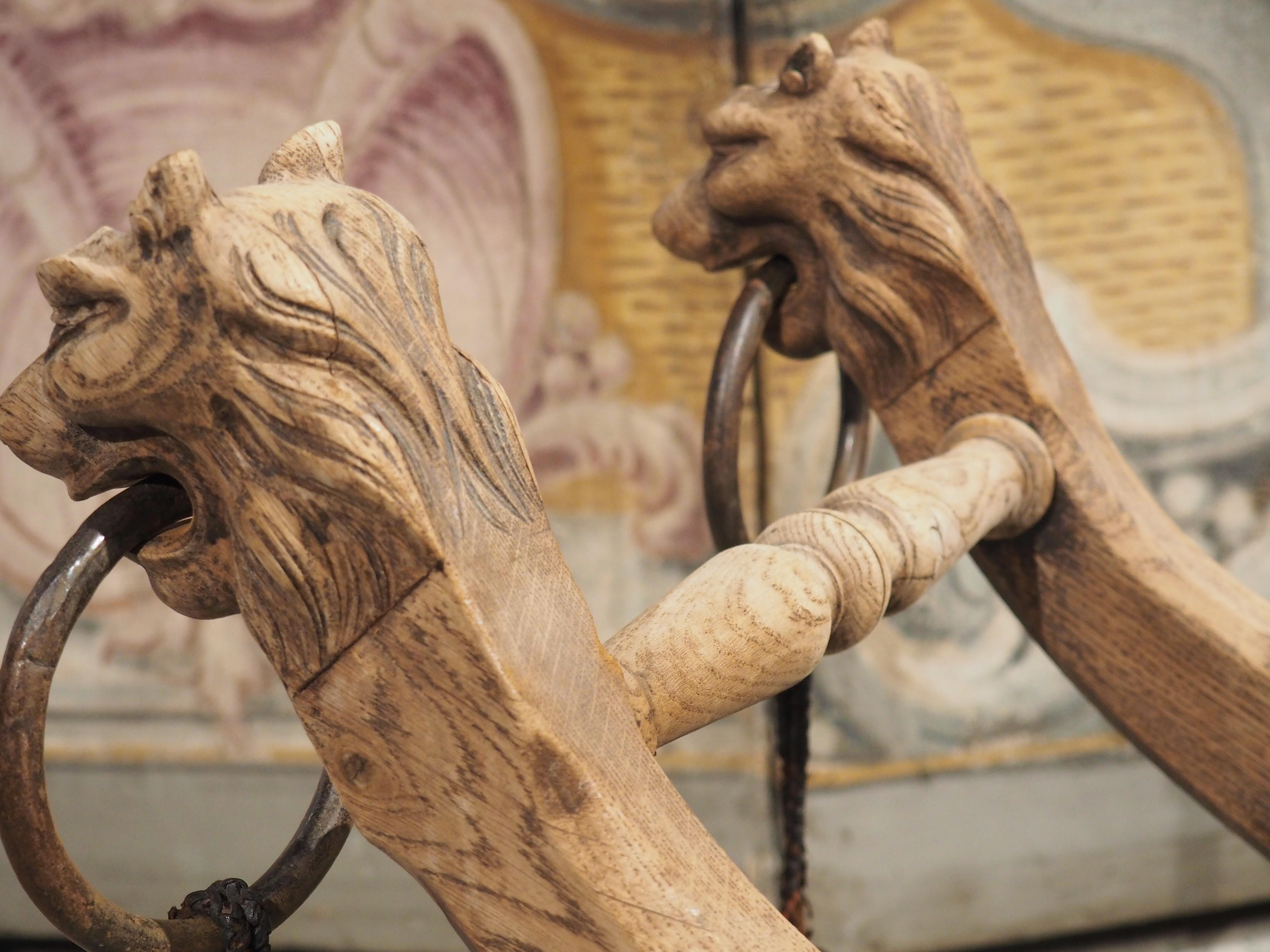 Hand-Carved Bleached French Oak Curule Bench with Lion Heads and Iron Rings, Circa 1920