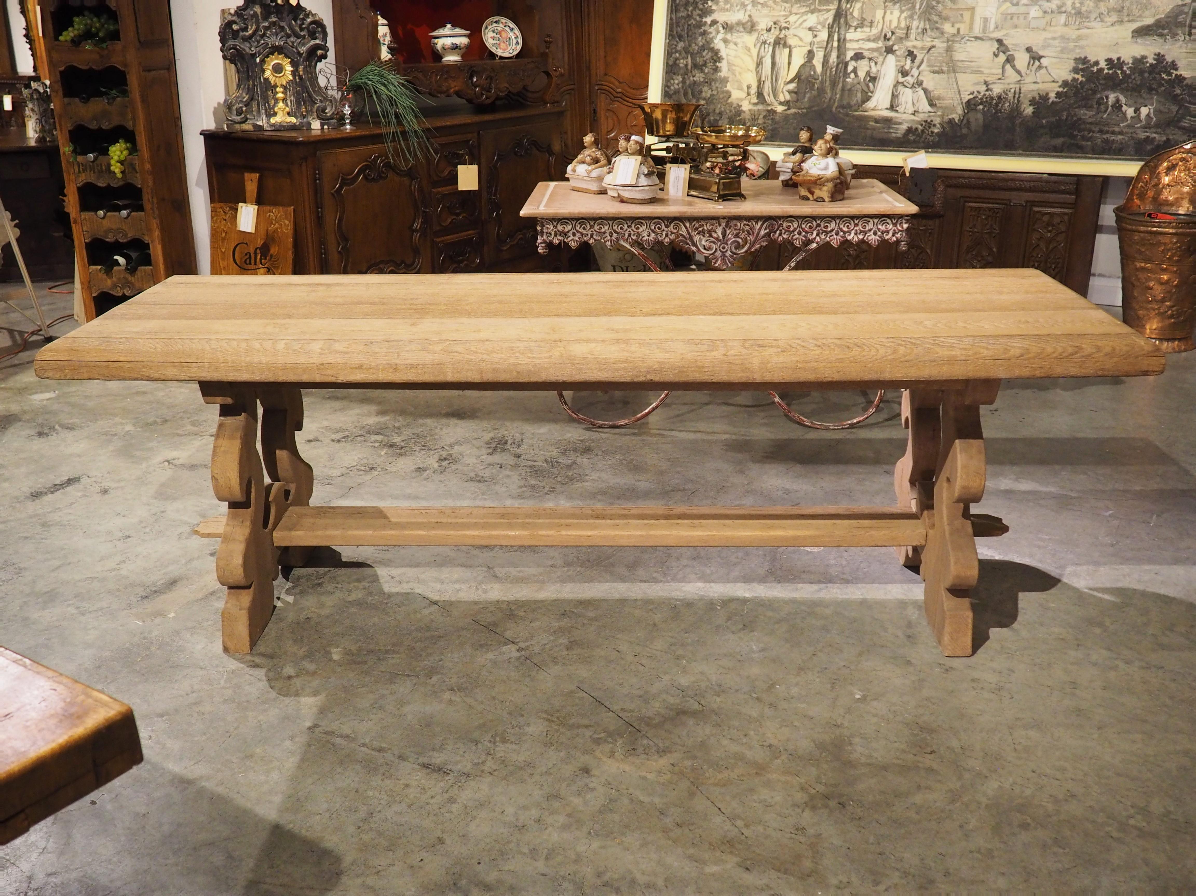 Produced in Italy during the 20th century, this bleached trestle table with thick, lyre shaped legs can be considered the Baroque style. The top of our table is comprised of several planks of oak that feature beautiful, large quarter round edges.