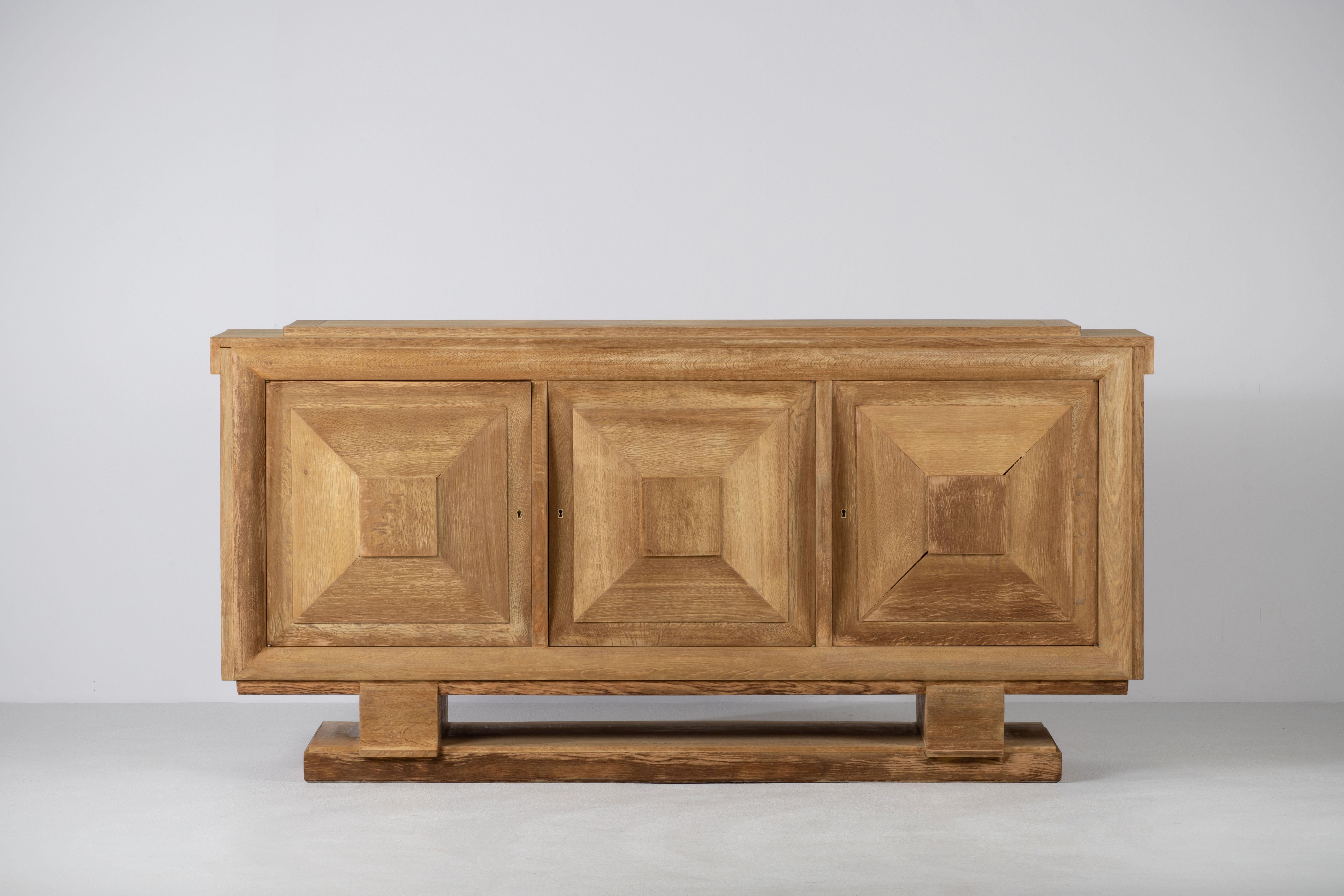 A large sideboard/credenza presumably by Charles Dudouyt. 
France, c1930s.
Consists of three doors providing shelves storage compartments and two central drawers. 
Graphic design doors make this piece really stand out.
The sideboard is in