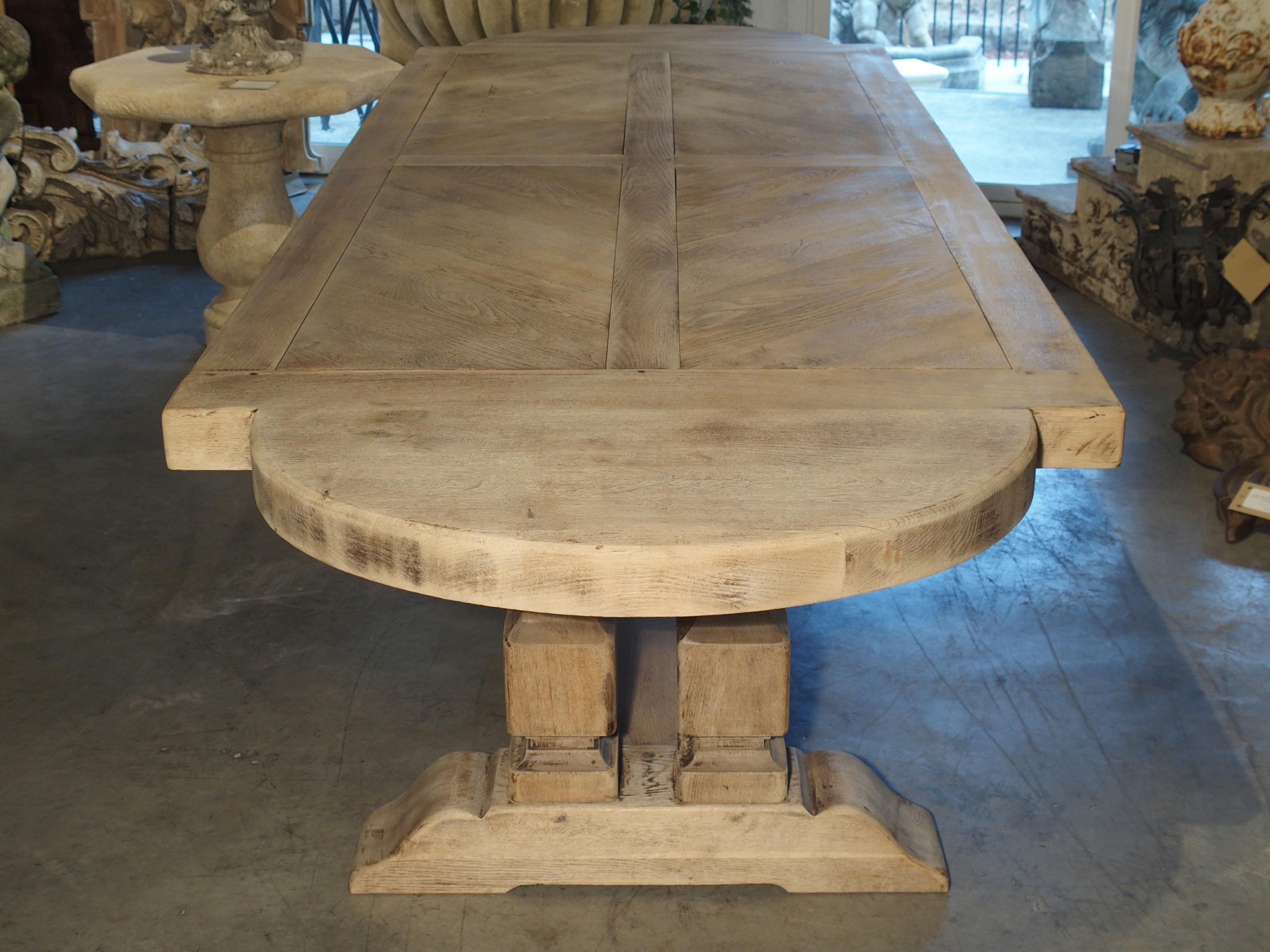 This beautiful and thick cut French dining table was made in the North of France in the early to mid-1900s. It was made of oak planks and then finished with a stain. Since then, it has been stripped and bleached, giving it a light and versatile