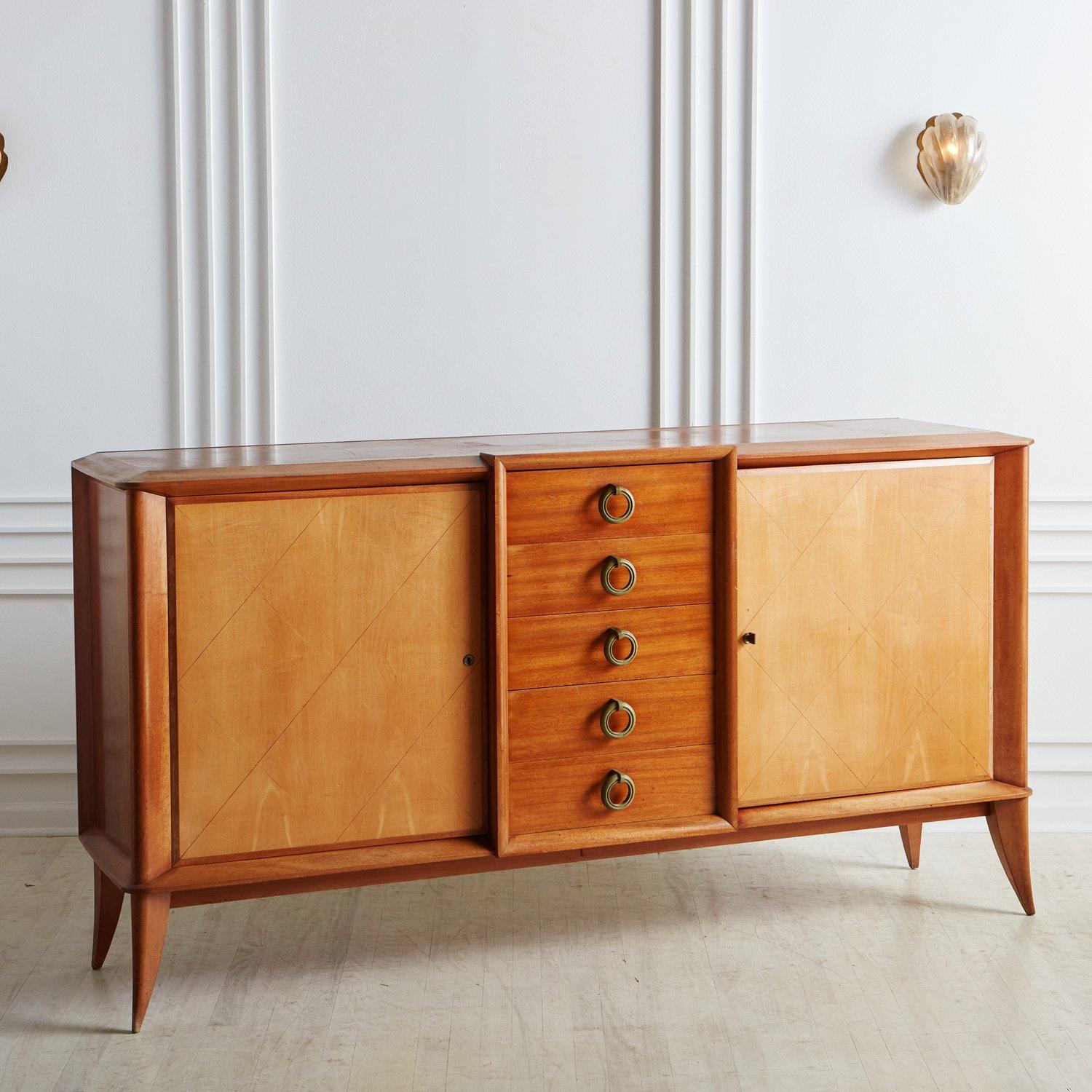 A gorgeous large scale credenza constructed with bleached mahogany featuring two birch doors with a subtle incised harlequin pattern. Each door opens to reveal one adjustable shelf with ample storage space. This piece has five center cherry wood