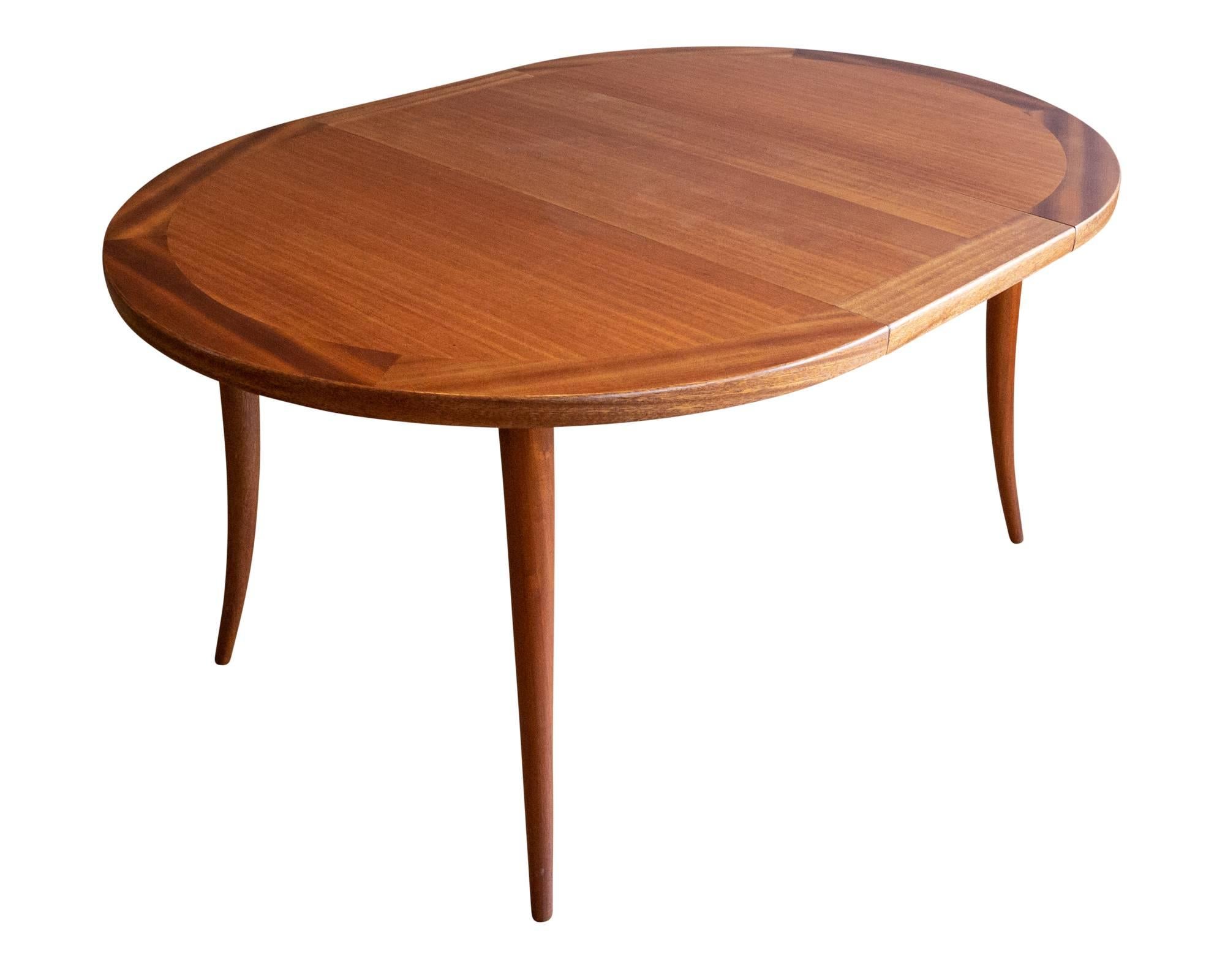 A rather handsome bleached mahogany dining table by American designer Harvey Probber, circa 1950s. Featuring a round top with parquetry border that opens to accommodate two 16
