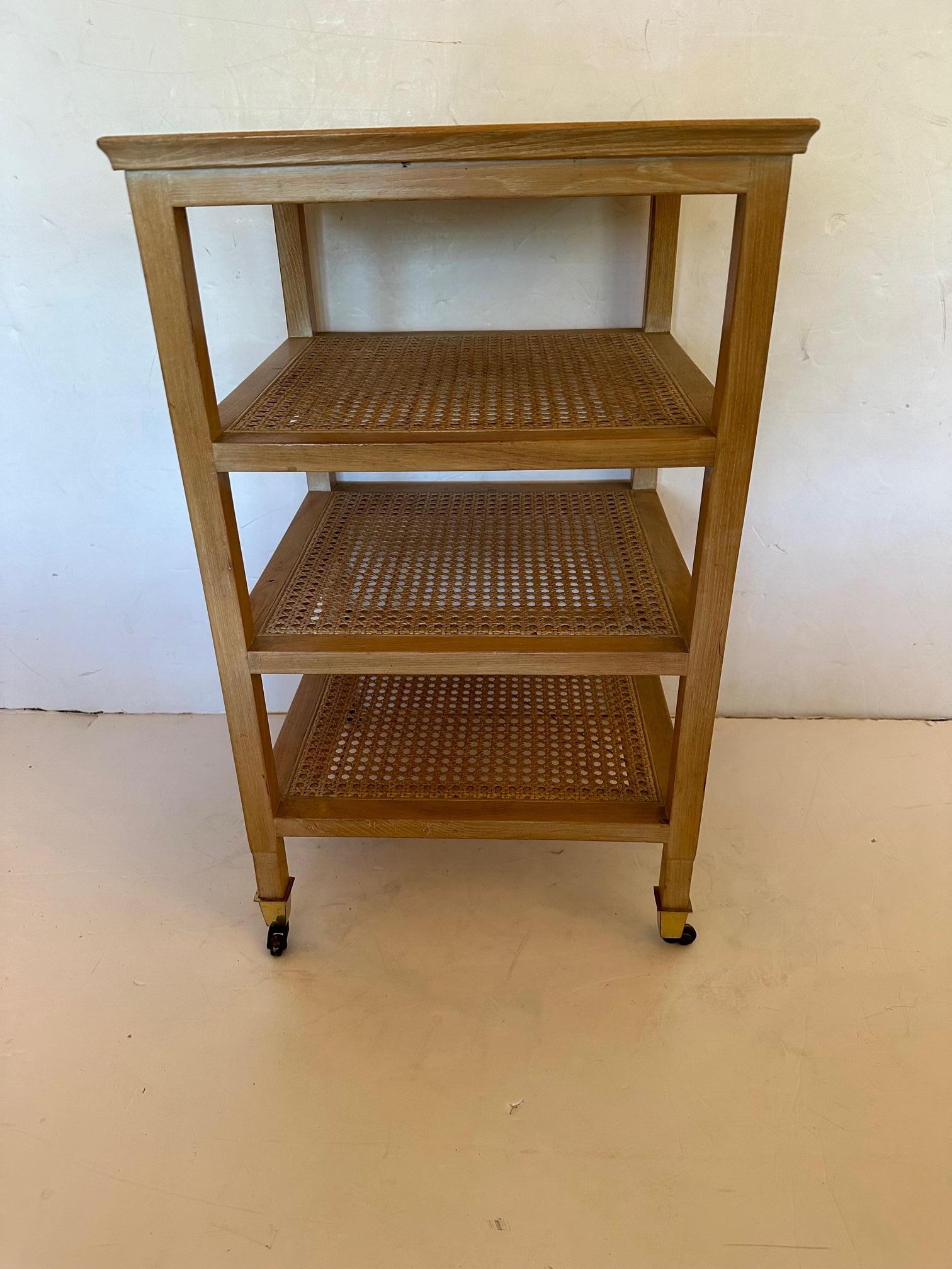 Great looking and versatile 4 shelf tiered bleached mahogany and caned side table having brass casters.