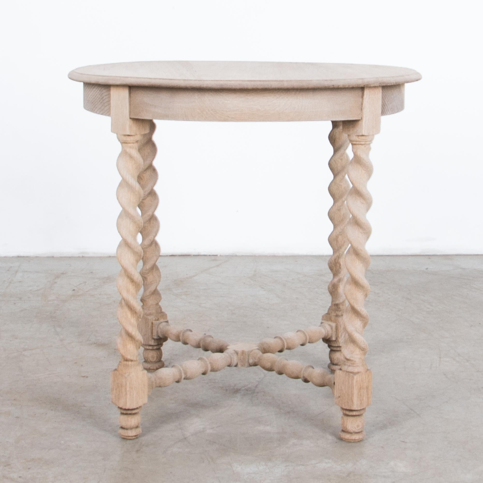 From France circa 1920, an oak side table with circular top. Carved in oak, this French Provincial table is simple and elegant, twisted barley columns recall the agrarian traditions of its countryside origin.