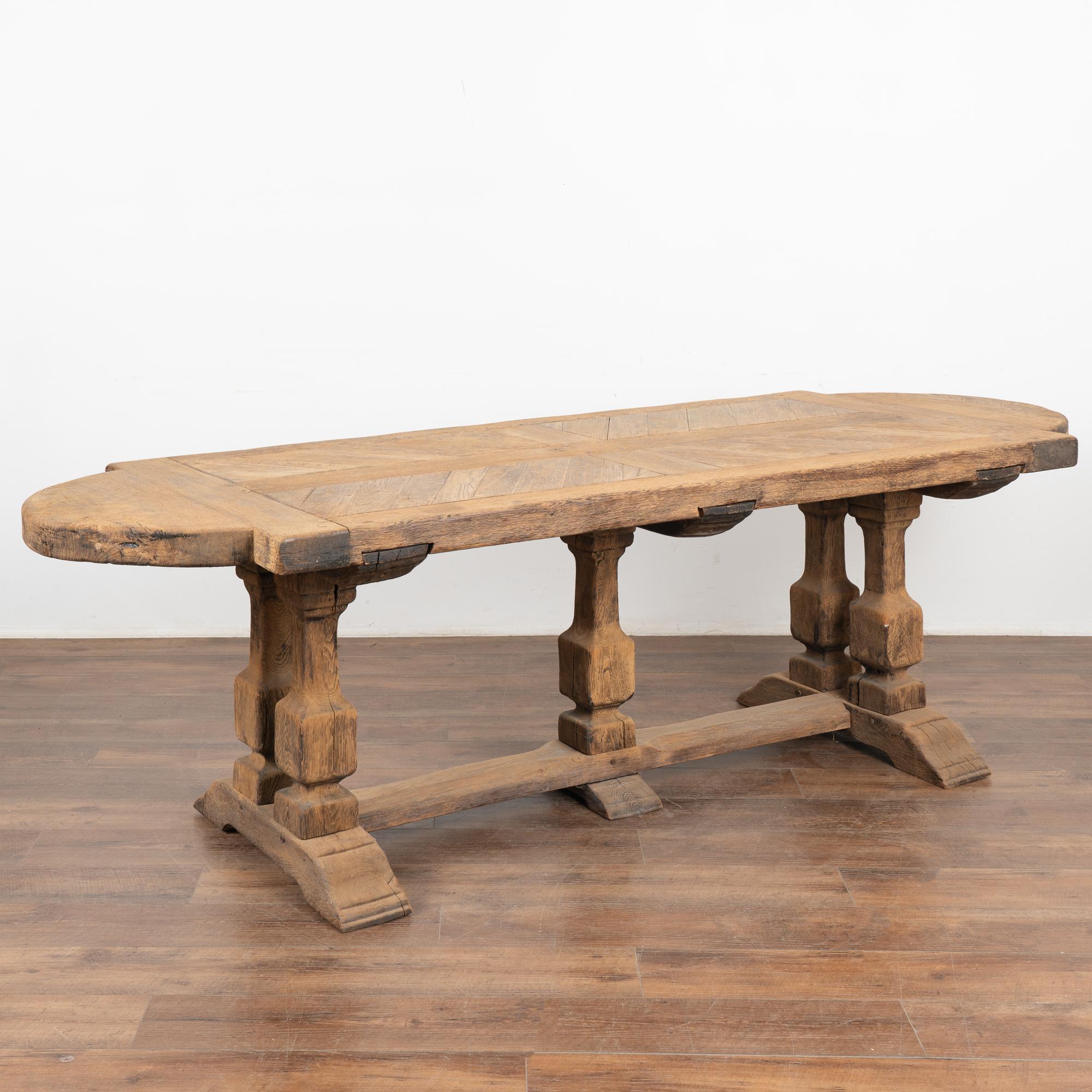 Large bleached oak dining table from France with impressive carved trestle base with heavy legs.
The original dark oak has been bleached, creating a fresh, lighter look for today's modern home. 
Note the intriguing pattern of oak in the heavy