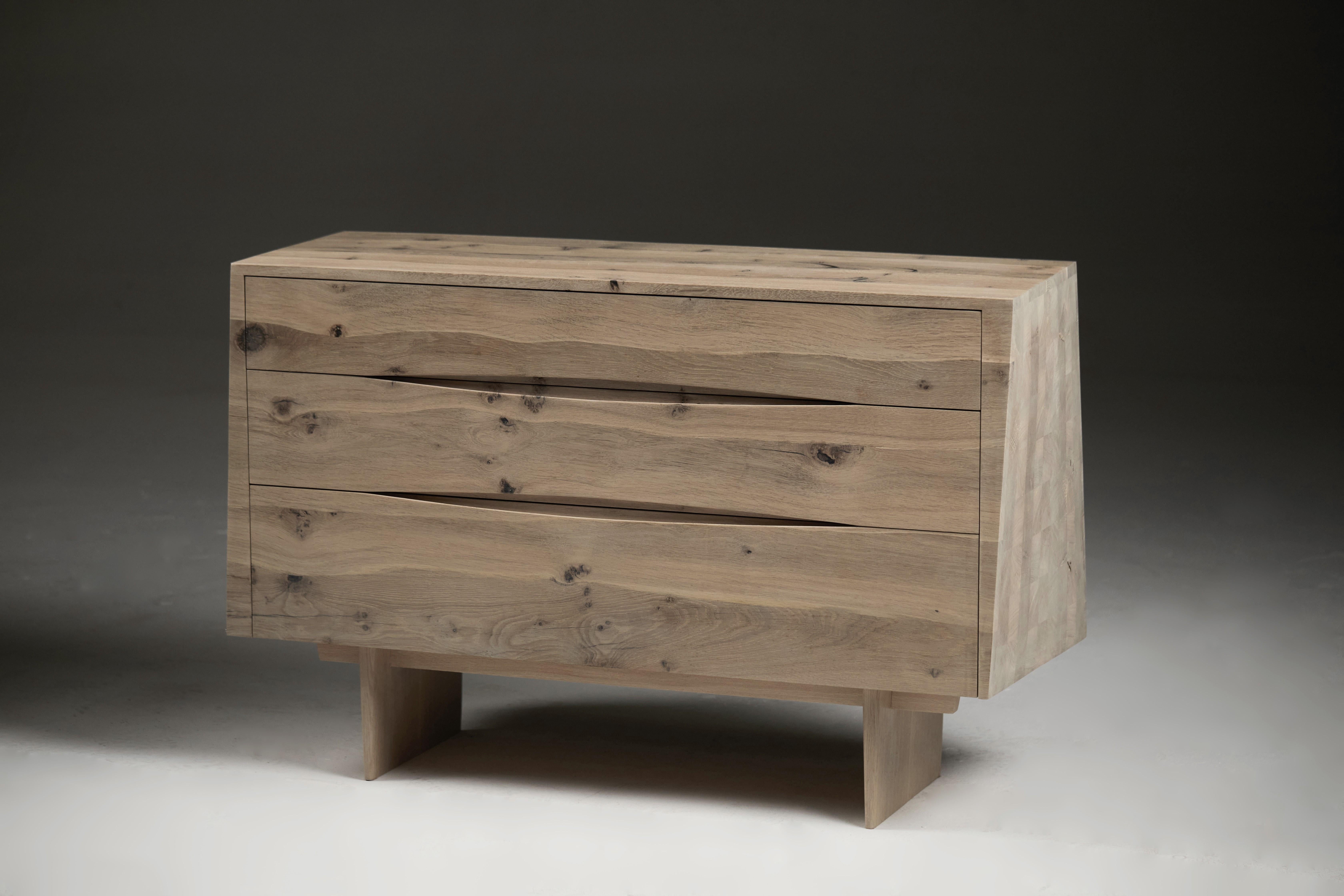 This low chest of drawers/sideboard is made from solid English oak that has been bleached to give a more monochrome colour, then protected with an almost invisible matt polyurethane two-pack with hardener, which offers a very durable surface. 
The